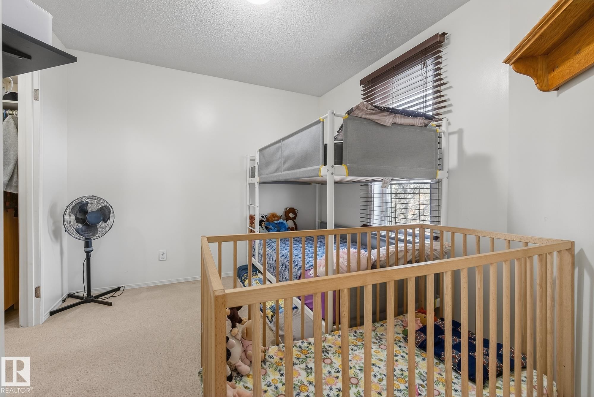 This room features neutral-toned carpet, a window with blinds, and white walls - 2006 Mill Woods Road E, Edmonton, AB - Indoor