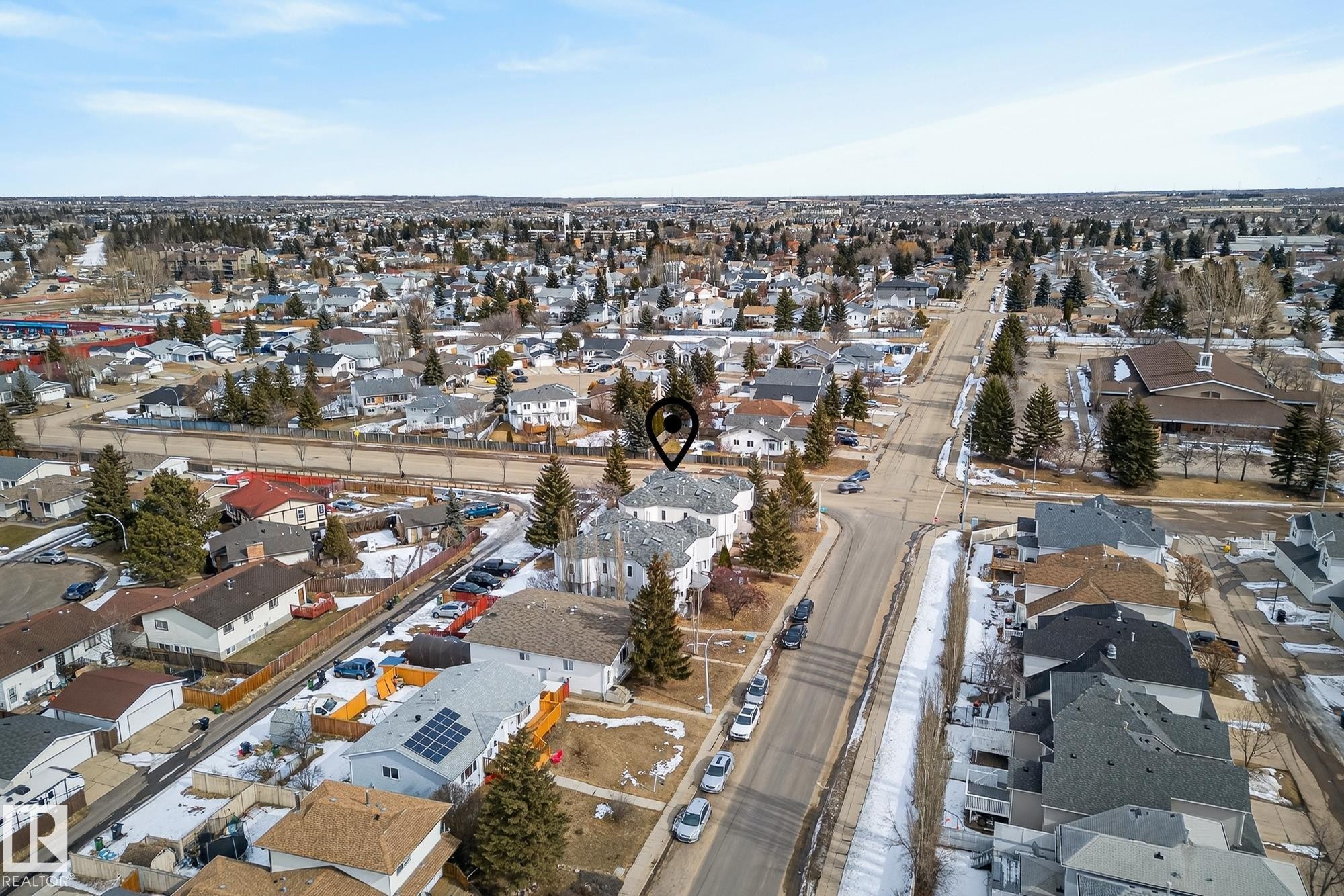 Aerial view of the property and its surrounding neighborhood, showcasing residential homes with sloped roofs, established trees, and paved roads - 2006 Mill Woods Road E, Edmonton, AB - Outdoor With View