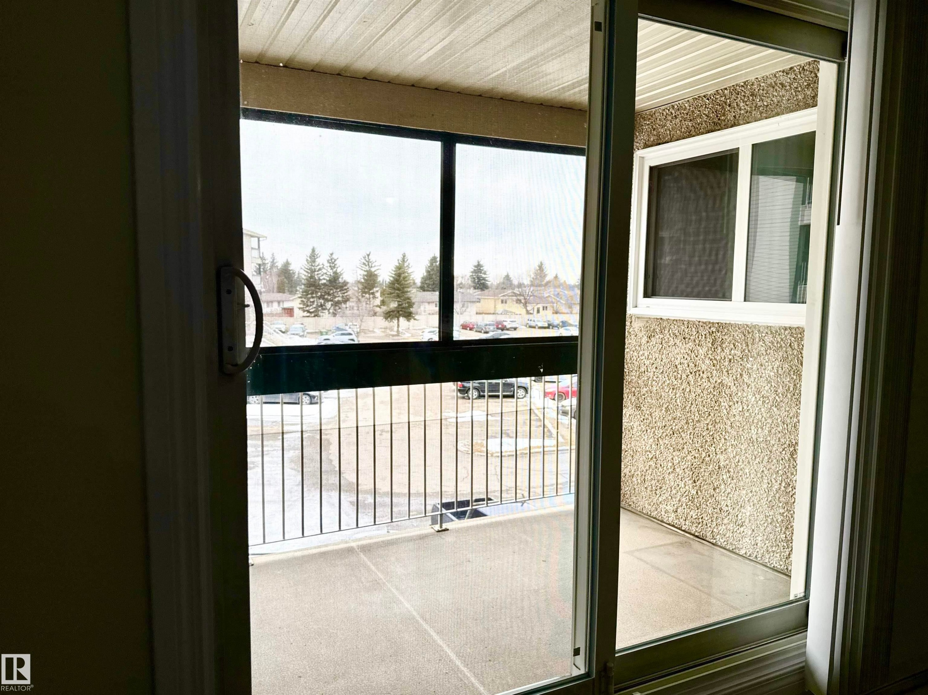 This property features a balcony with a metal railing and an exterior textured wall - 307 1620 48 Street, Edmonton, AB