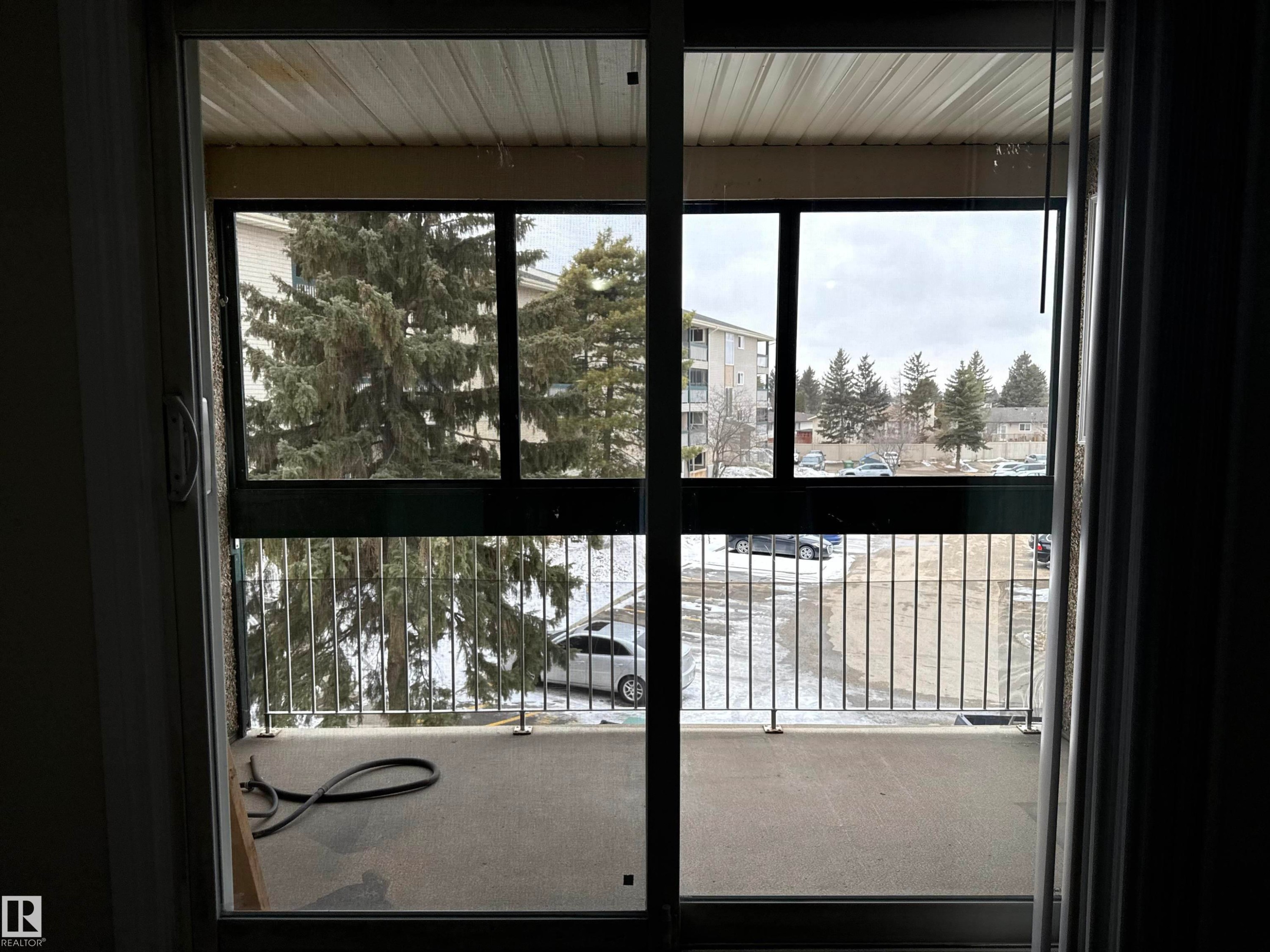 The property features a balcony with a metal railing and a view of surrounding mature trees - 307 1620 48 Street, Edmonton, AB