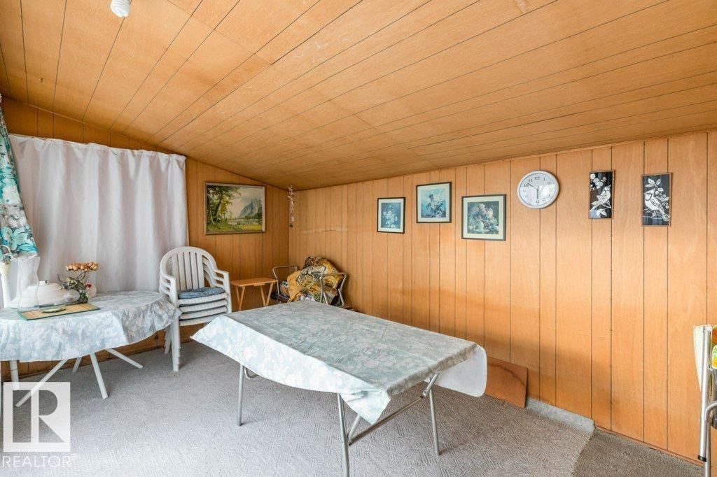 Living area with wooden walls, carpet floors, wooden ceiling, and lofted ceiling - 8810 93 Street, Edmonton, AB - Photo Showing Other Room