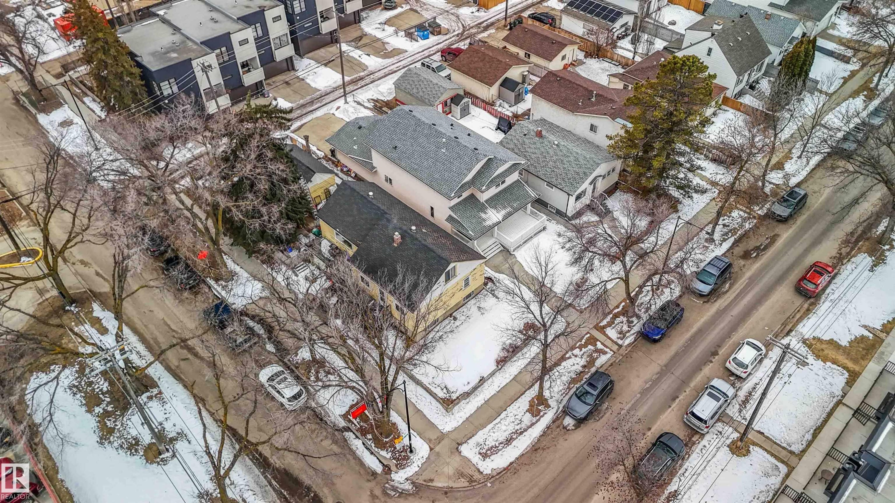 Aerial view of the property and its surrounding streets, featuring residential buildings and tree-lined sidewalks - 10186 143 Street, Edmonton, AB -