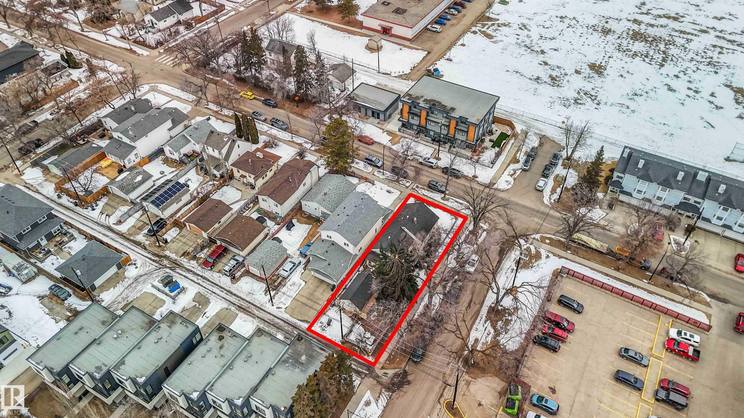 Aerial view of the property, highlighted in red, situated within a neighborhood featuring a mix of residential structures and commercial lots - 10186 143 Street, Edmonton, AB -