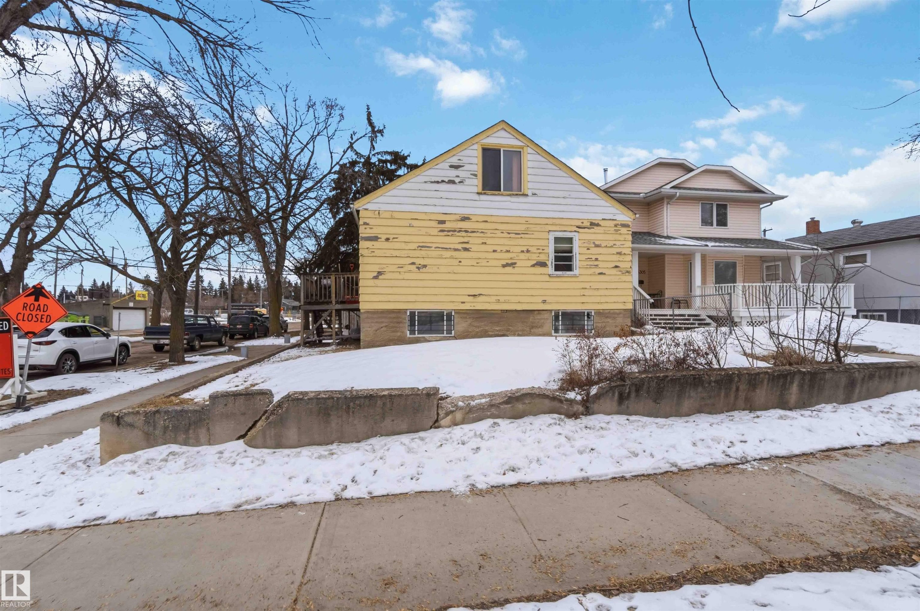 The property features a yellow exterior with white trim and a gabled roof - 10186 143 Street, Edmonton, AB - Outdoor