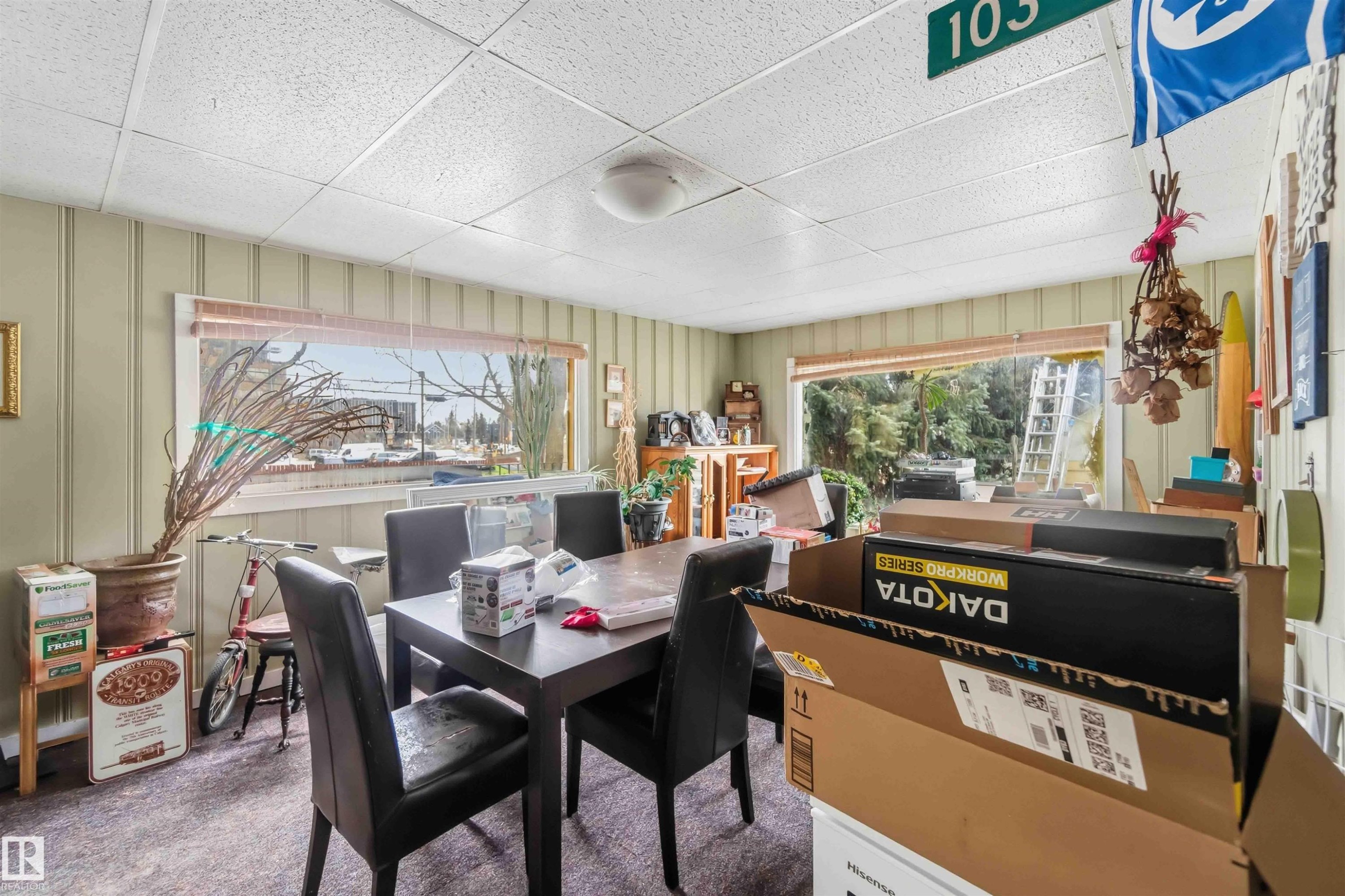 This dining area features panelled walls and large windows, providing views of the exterior - 10186 143 Street, Edmonton, AB - Indoor Photo Showing Dining Room