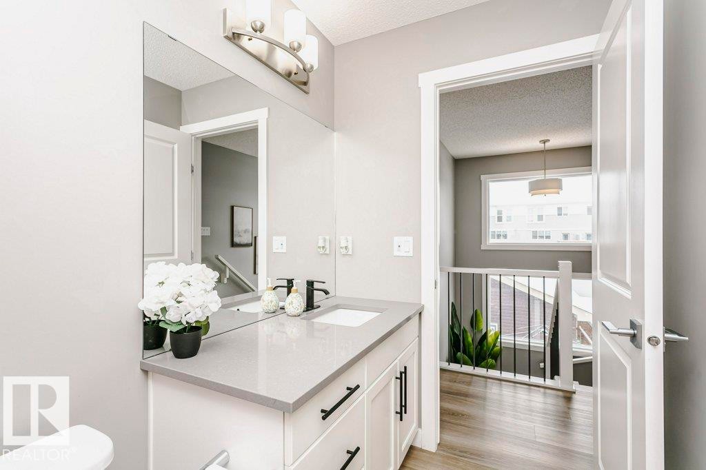 Bathroom vanity featuring a light gray countertop, a rectangular undermount sink, and a large wall-mounted mirror - 320 Balsam Link, Leduc, AB - Indoor Photo Showing Bathroom
