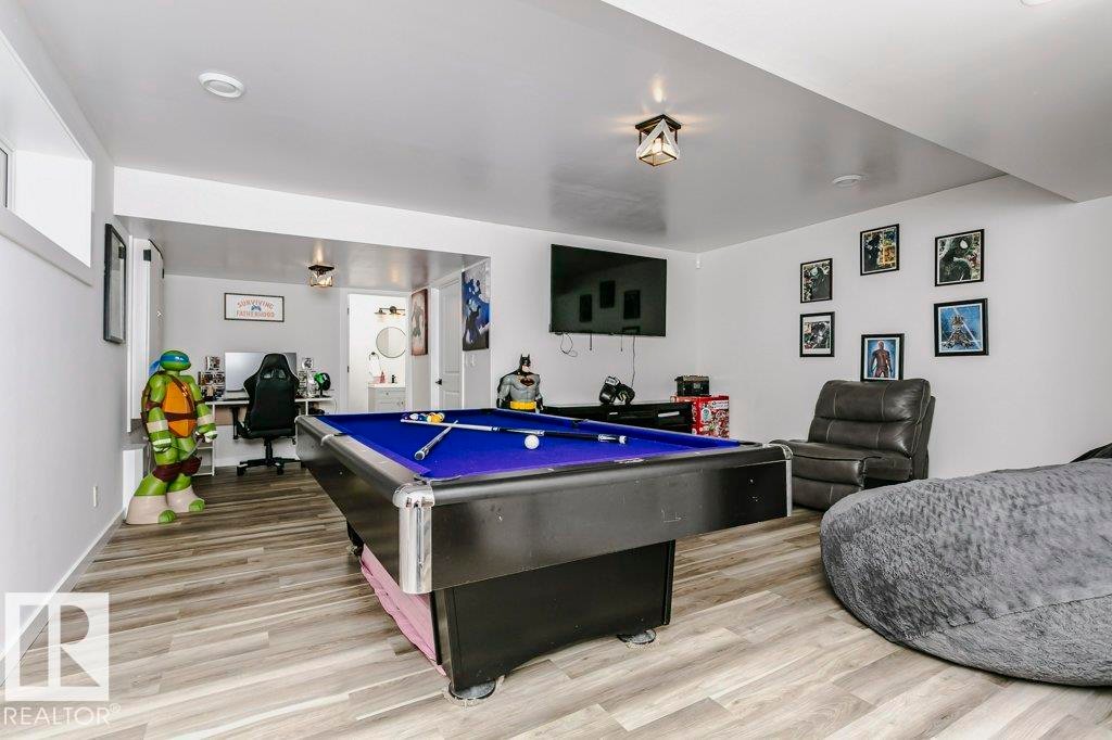 Recreational space featuring wood-look flooring, a pool table with a blue felt surface, and white walls - 320 Balsam Link, Leduc, AB - Indoor Photo Showing Other Room