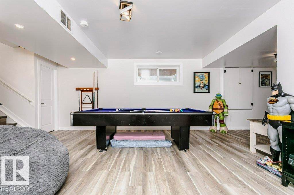 Spacious finished basement featuring light-toned flooring, white walls, and a window providing natural light - 320 Balsam Link, Leduc, AB - Indoor Photo Showing Other Room