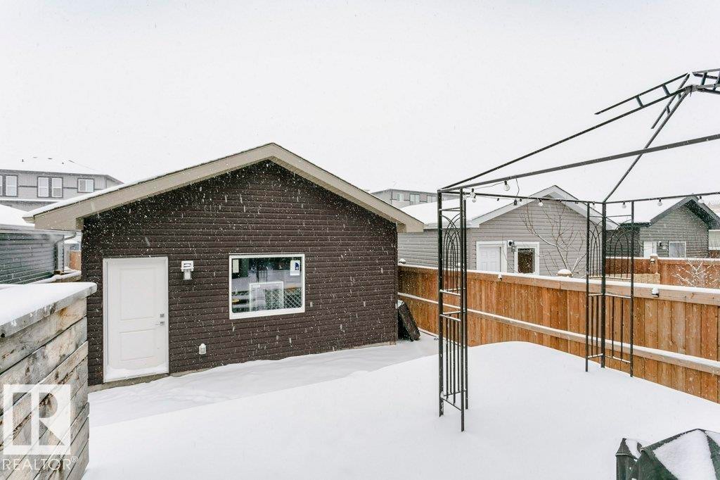 The property features a detached structure with brown siding, a white door, and a white-framed window - 320 Balsam Link, Leduc, AB - Outdoor With Exterior