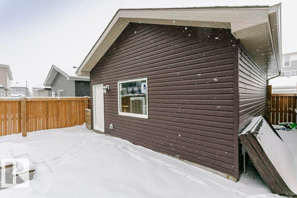 Detached structure featuring dark brown horizontal siding, a white door, and a white-trimmed window - 320 Balsam Link, Leduc, AB - Outdoor With Exterior