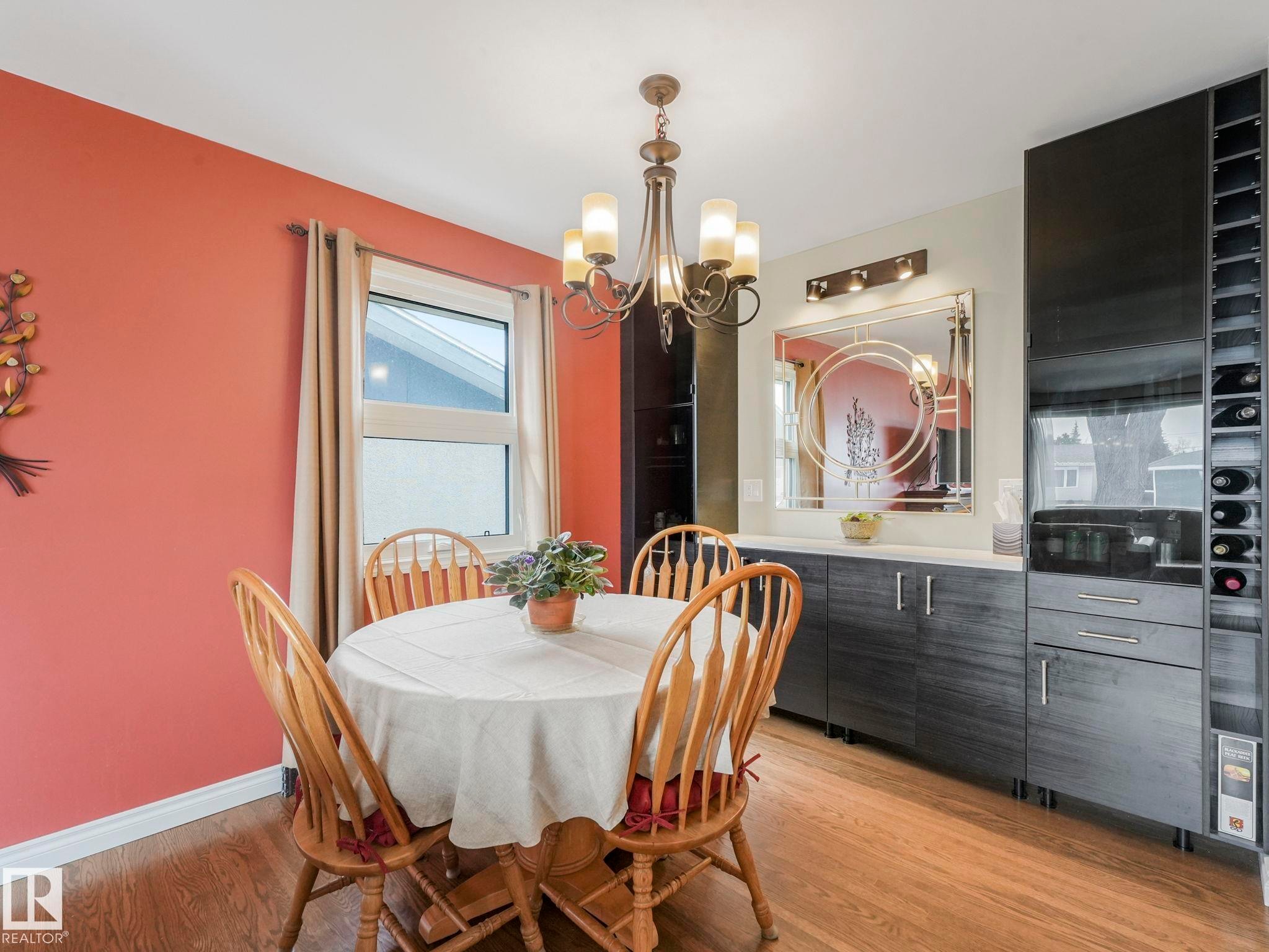 This dining area features laminate darker floors and a modern chandelier - 16106 79A Avenue Nw, Edmonton, AB - Indoor Photo Showing Dining Room
