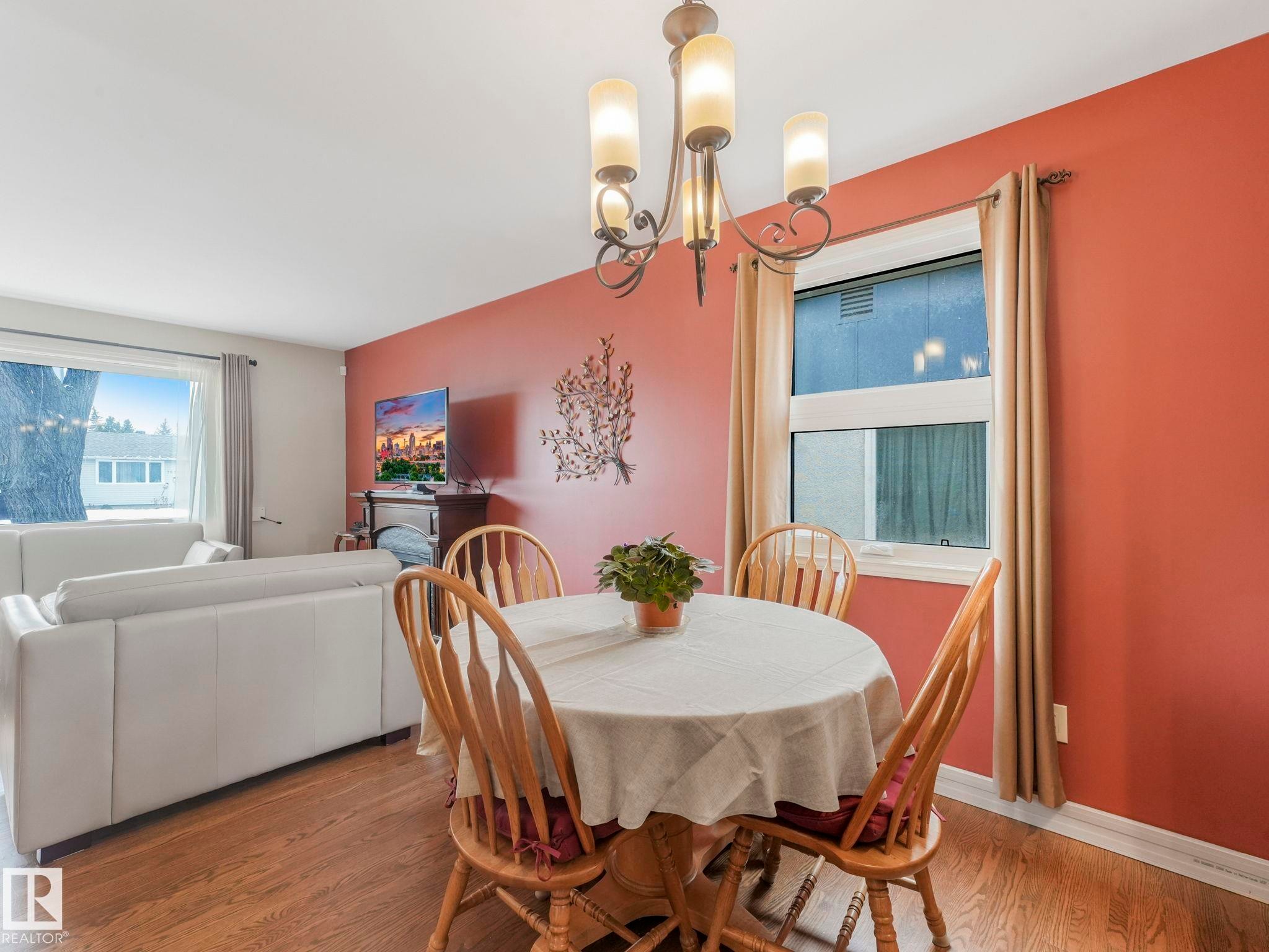 This inviting dining area features hardwood flooring and a chandelier, creating a warm ambiance - 16106 79A Avenue Nw, Edmonton, AB - Indoor Photo Showing Dining Room