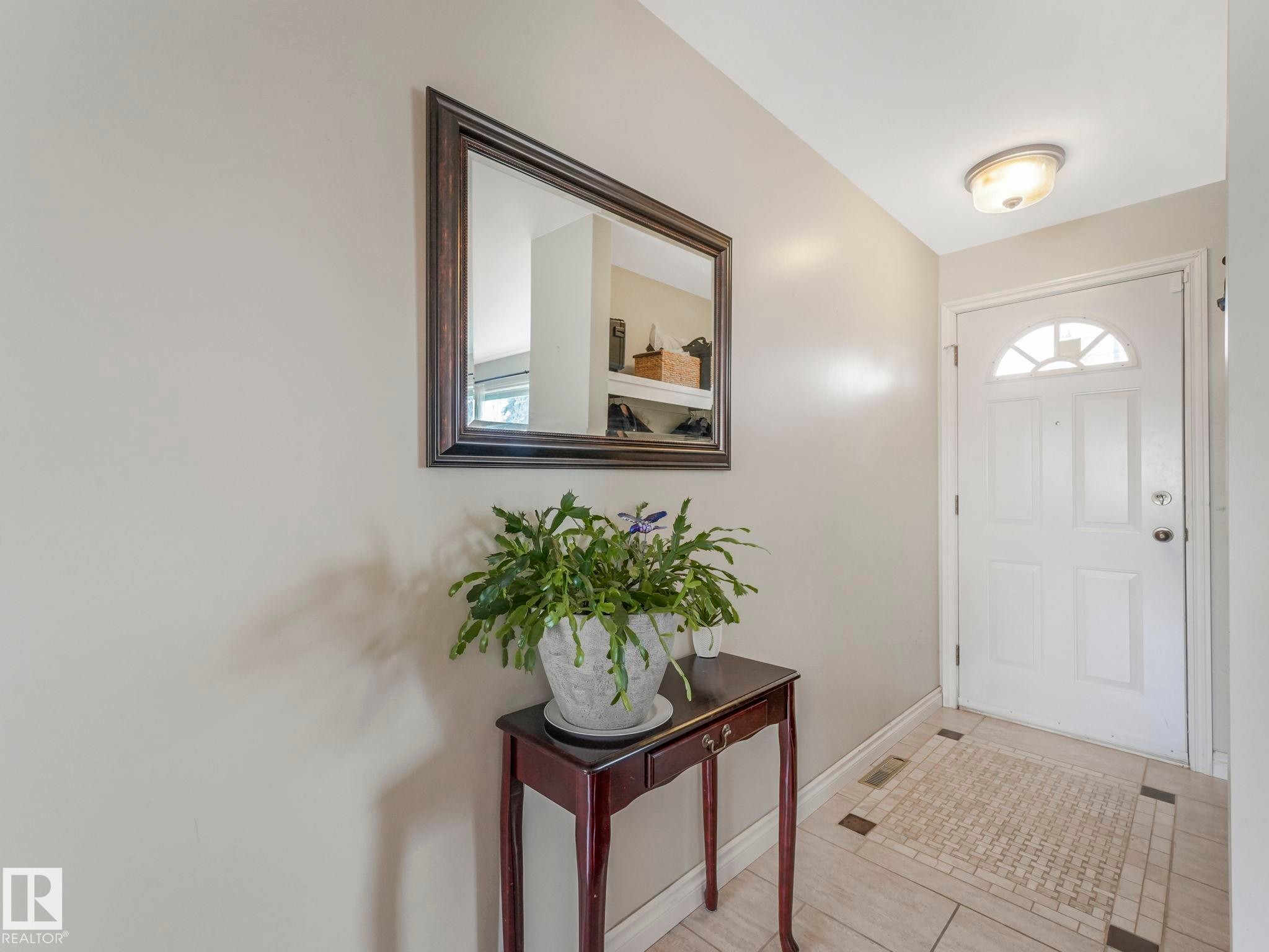 The entryway features a white door with an arched window, light-colored walls, and a ceiling light fixture - 16106 79A Avenue Nw, Edmonton, AB - Indoor Photo Showing Other Room