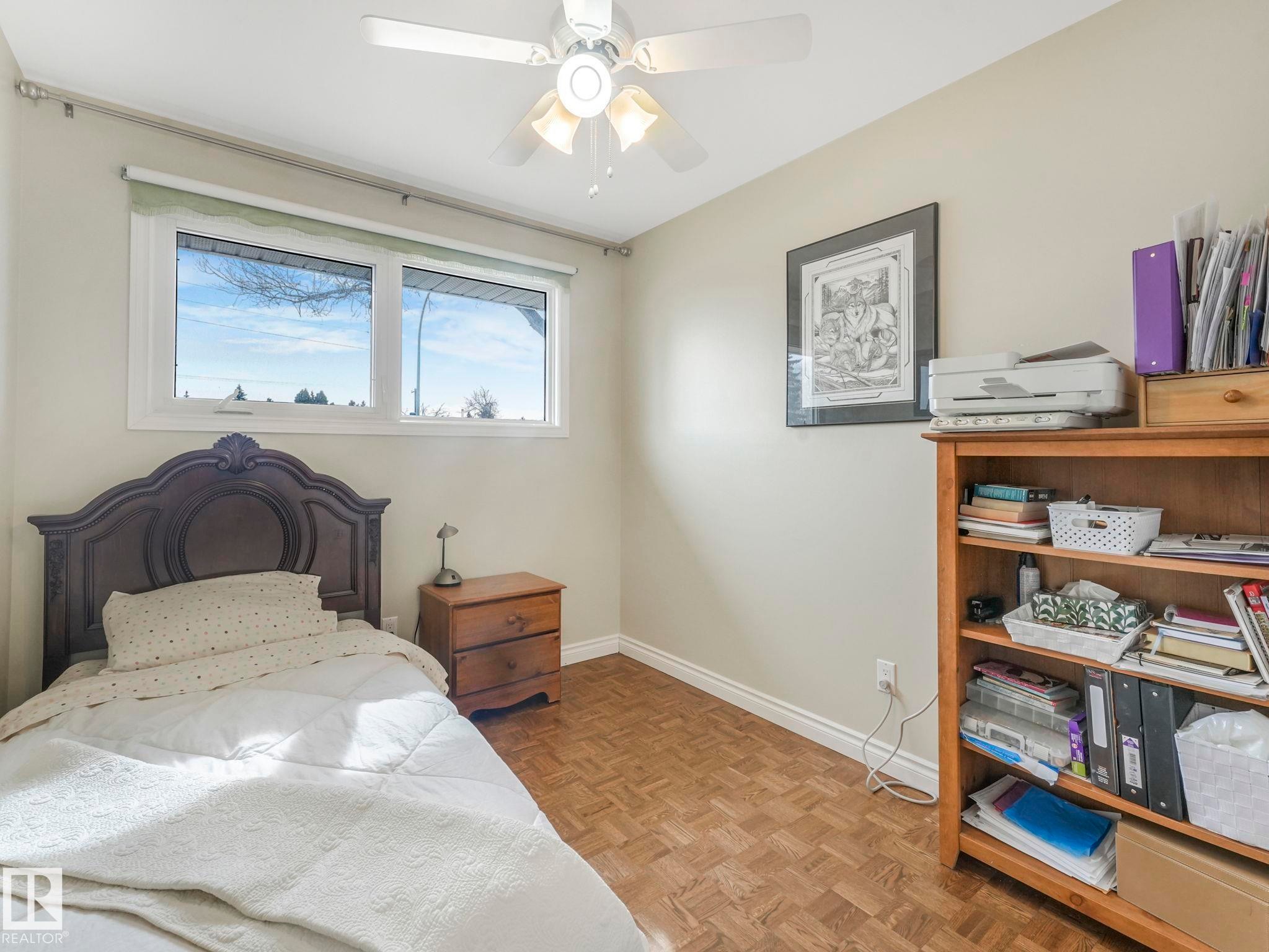 This room features parquet flooring, a ceiling fan, and a window providing natural light - 16106 79A Avenue Nw, Edmonton, AB - Indoor Photo Showing Bedroom