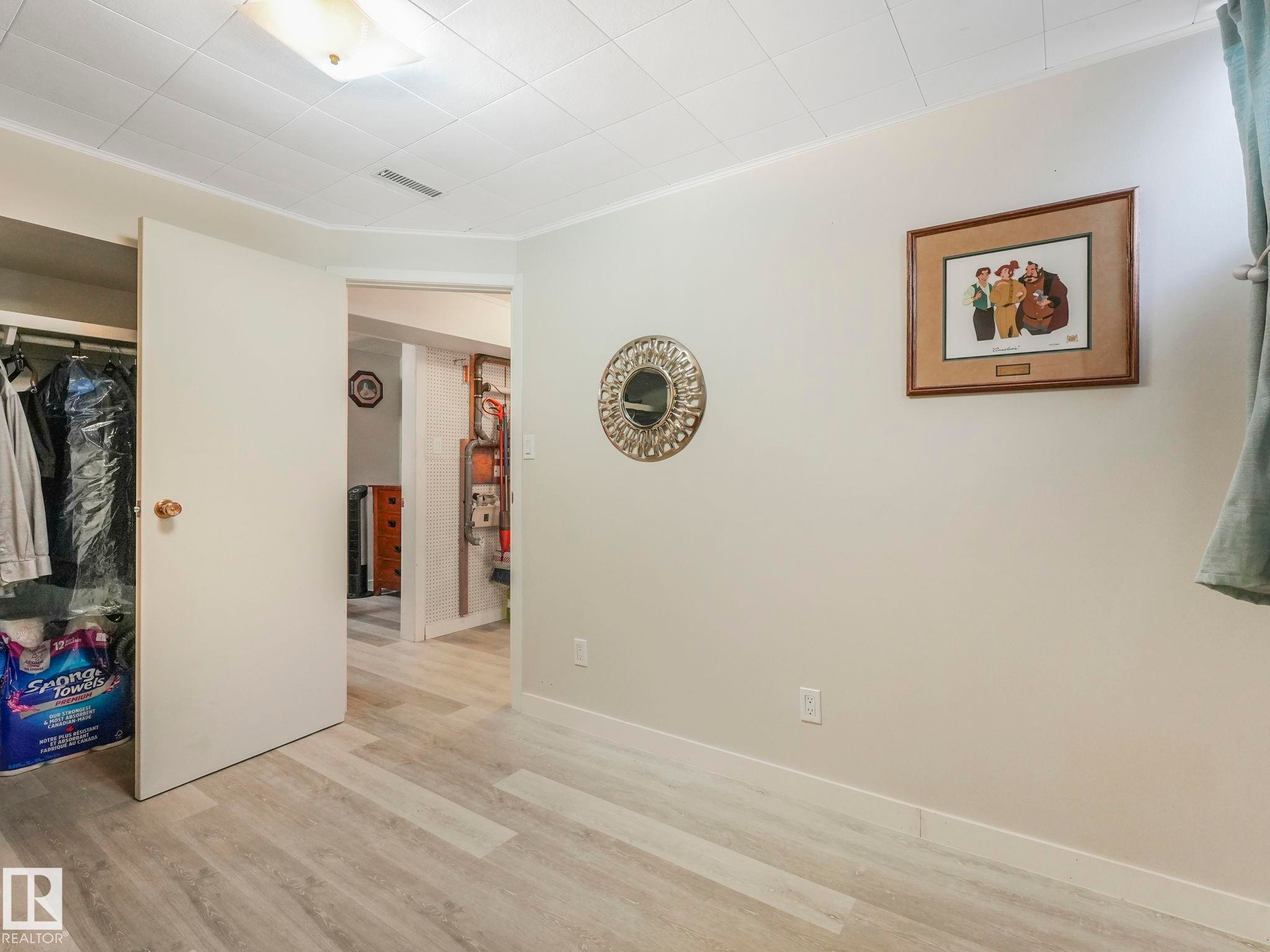 This room features light-colored walls, a closet with an open door, and light-toned plank flooring - 16106 79A Avenue Nw, Edmonton, AB - Indoor Photo Showing Other Room