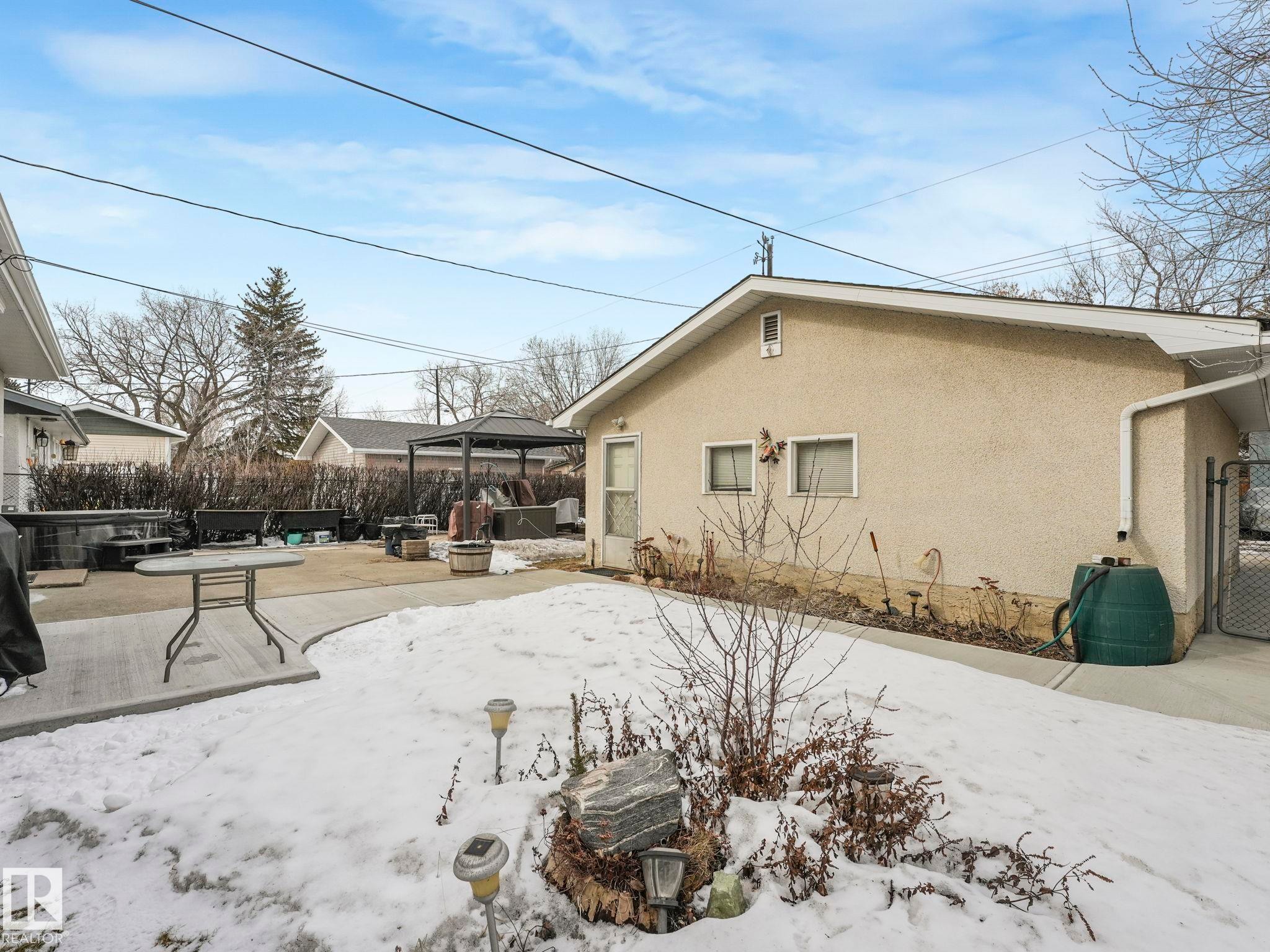 The property features a concrete patio area and a fenced side yard - 16106 79A Avenue Nw, Edmonton, AB - Outdoor