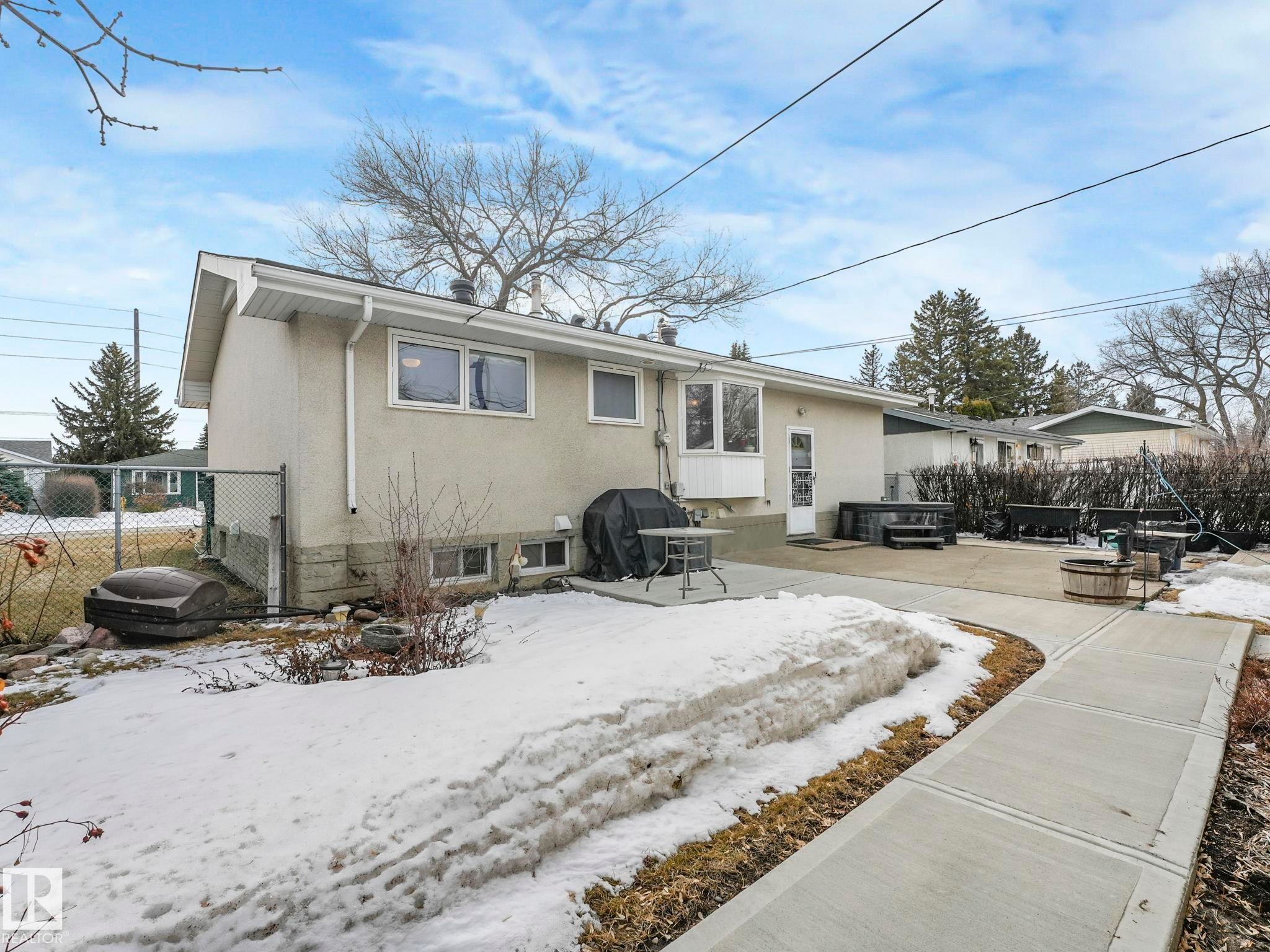 The property features a concrete patio area, accessible via an exterior door, and a concrete pathway - 16106 79A Avenue Nw, Edmonton, AB - Outdoor