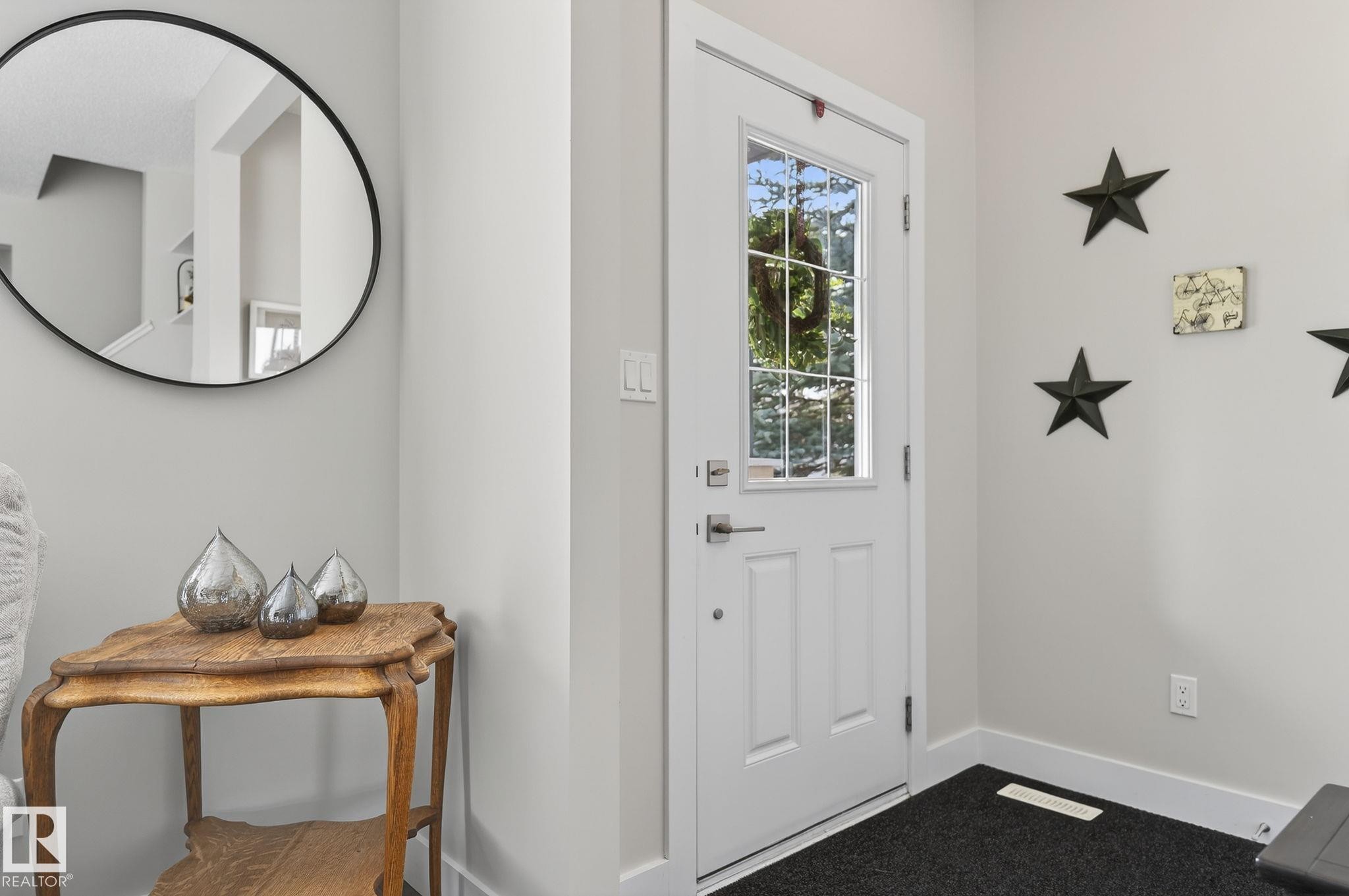 Entryway featuring a white door with a window, light gray walls, and a black circular mirror - 9084 Rosenthal Link, Edmonton, AB - Indoor Photo Showing Other Room