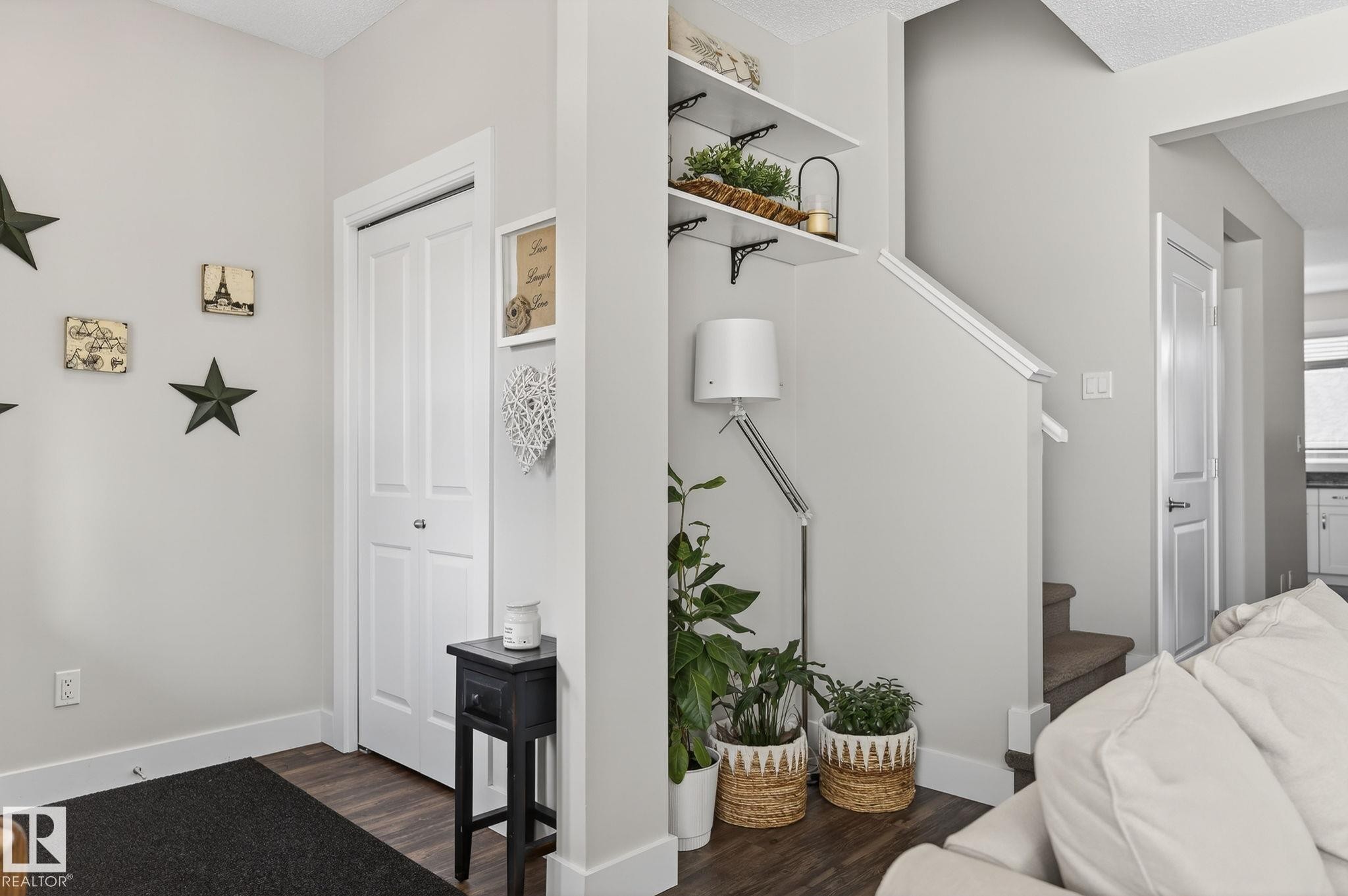 The property features contemporary light grey walls, dark plank flooring, and white baseboards - 9084 Rosenthal Link, Edmonton, AB - Indoor