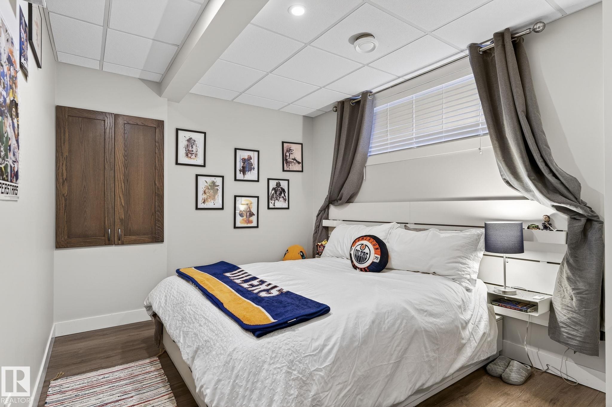 This room features a drop ceiling with recessed lighting and wood-look flooring - 9084 Rosenthal Link, Edmonton, AB - Indoor Photo Showing Bedroom