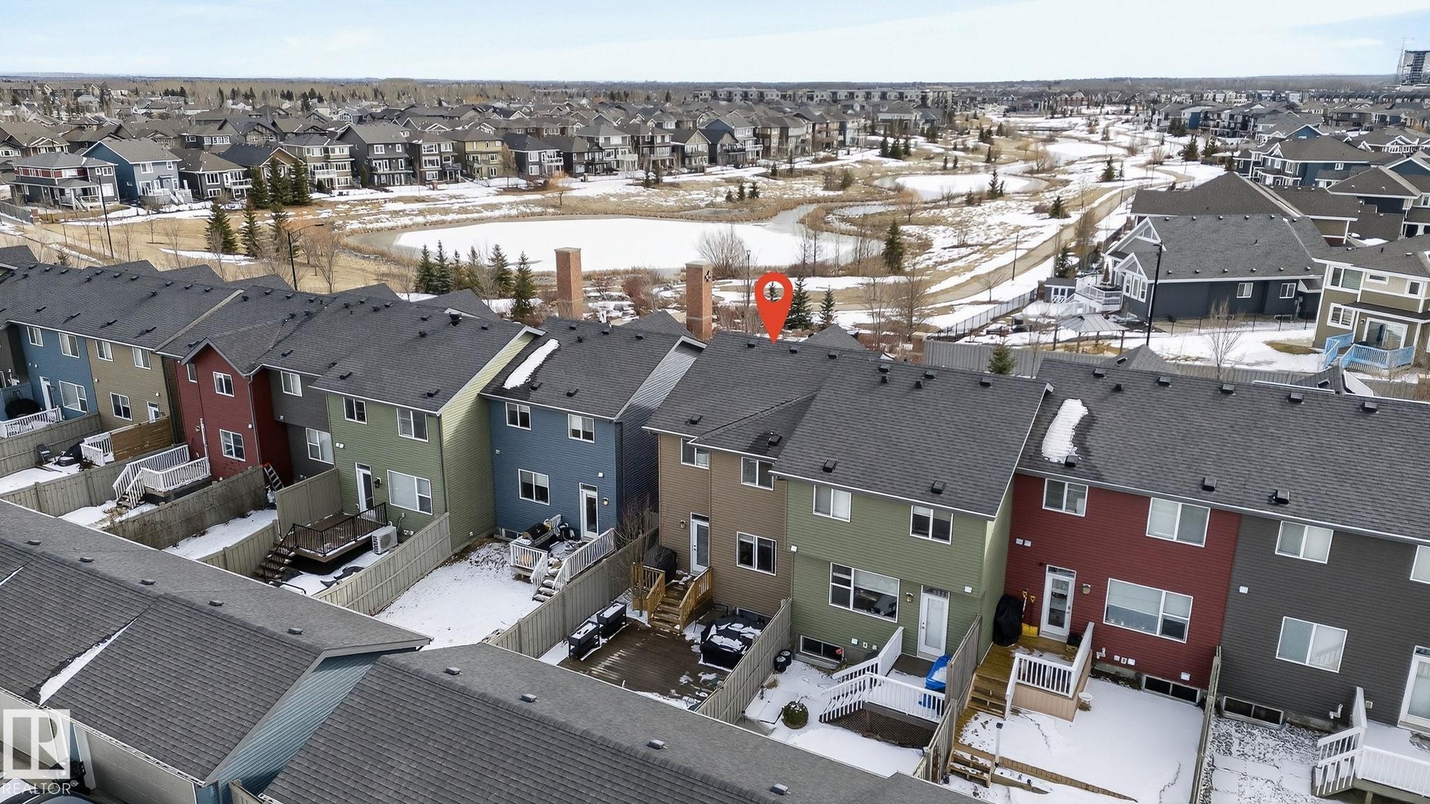The property features a dark-colored roof and a private fenced yard with a deck - 9084 Rosenthal Link, Edmonton, AB - Outdoor