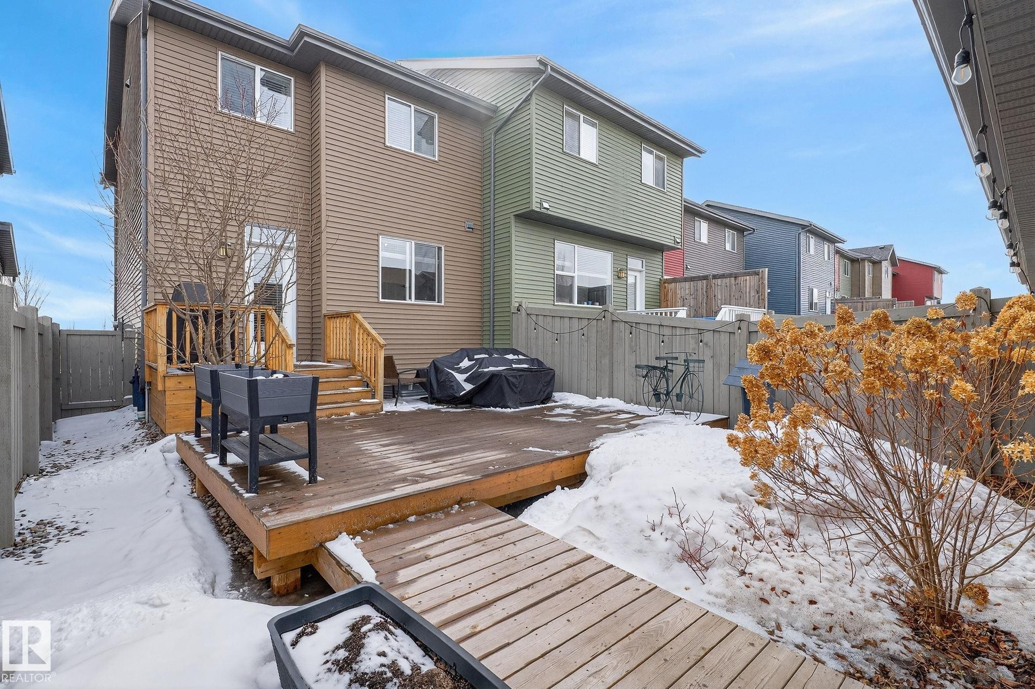 The property features a wooden deck with railing and stairs, providing outdoor space - 9084 Rosenthal Link, Edmonton, AB - Outdoor With Deck Patio Veranda With Exterior