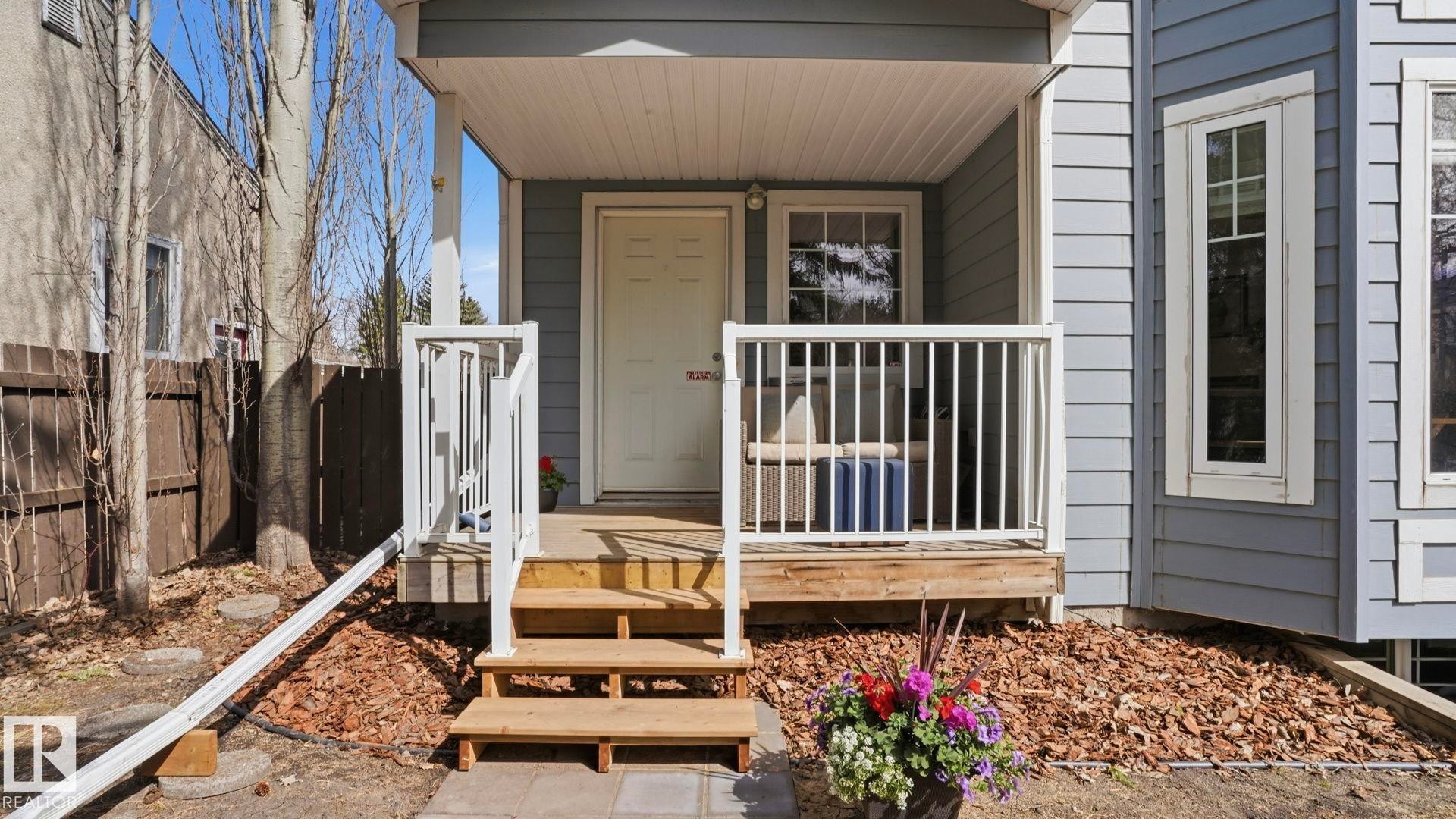 Covered front porch with wood-finish steps and white railing - 7235 112 Street, Edmonton, AB - Outdoor