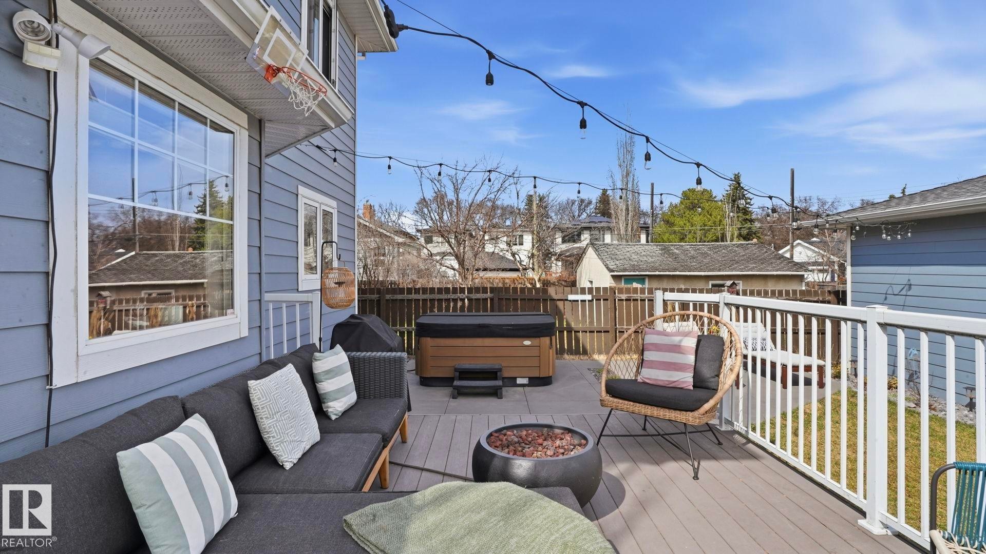 Spacious outdoor deck featuring composite decking, white railing, and exterior string lighting - 7235 112 Street, Edmonton, AB - Outdoor With Deck Patio Veranda With Exterior