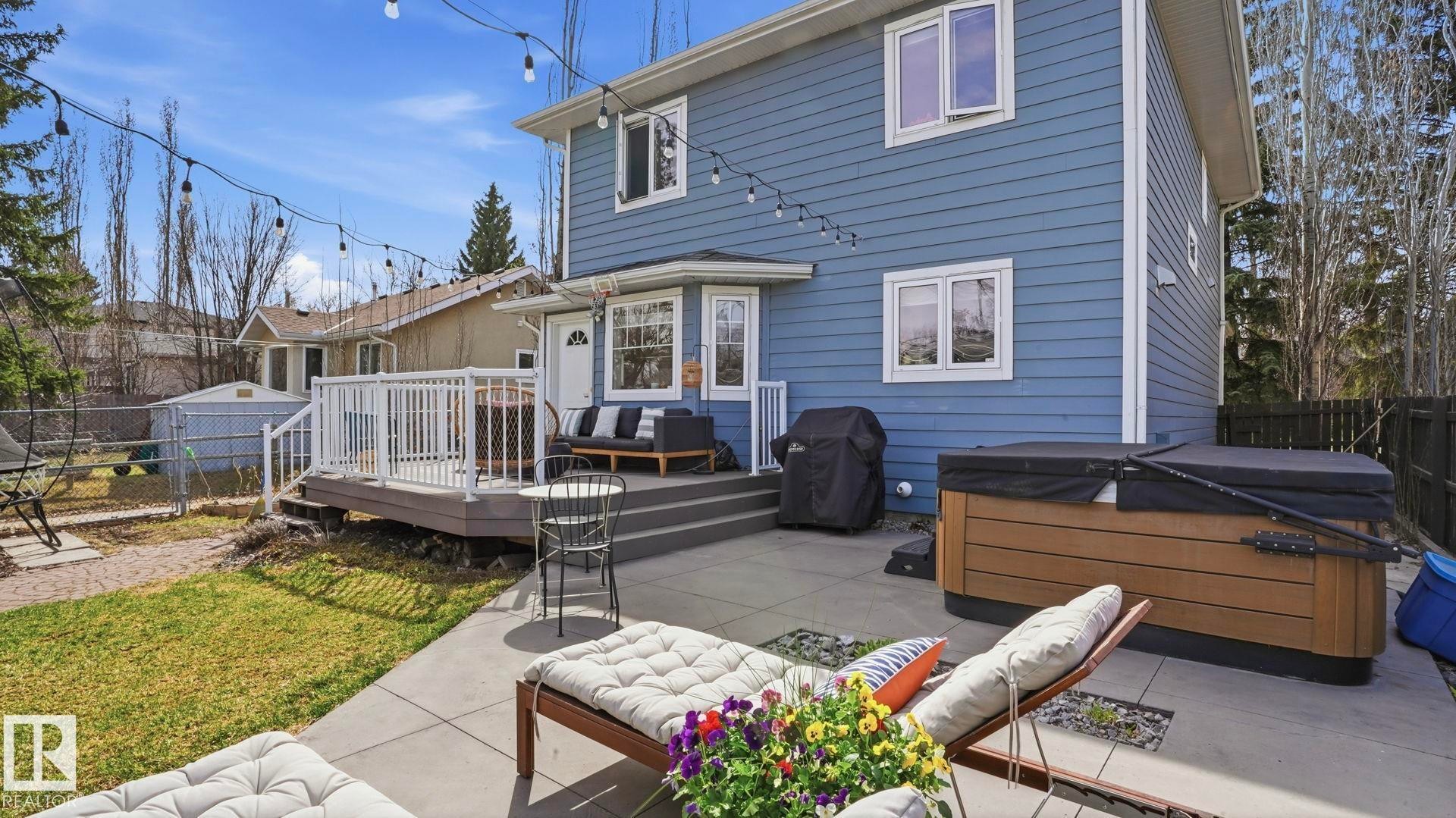 Expansive rear exterior featuring a multi-level deck, concrete patio, and a covered hot tub - 7235 112 Street, Edmonton, AB - Outdoor With Deck Patio Veranda With Exterior