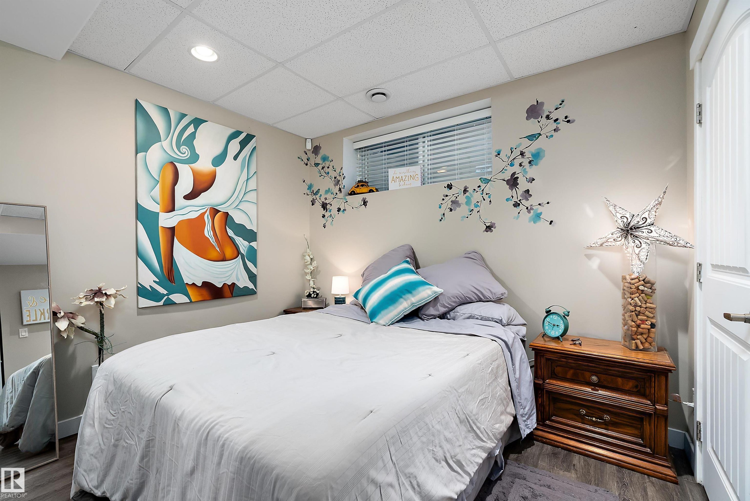 This versatile space features a vibrant wall mural, recessed lighting, and a neutral wall color, providing a dynamic backdrop for various activities - 2914 18A Avenue, Edmonton, AB - Indoor