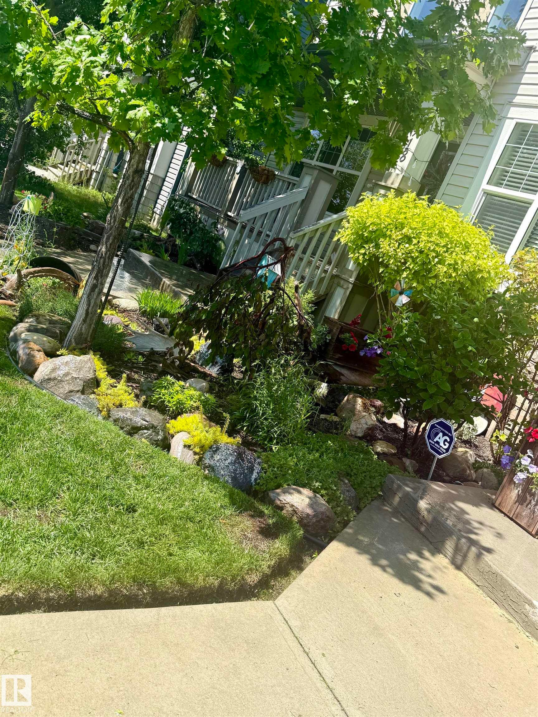 The property features a well-maintained lawn and a garden area with various plants and rocks - 2914 18A Avenue, Edmonton, AB - Outdoor