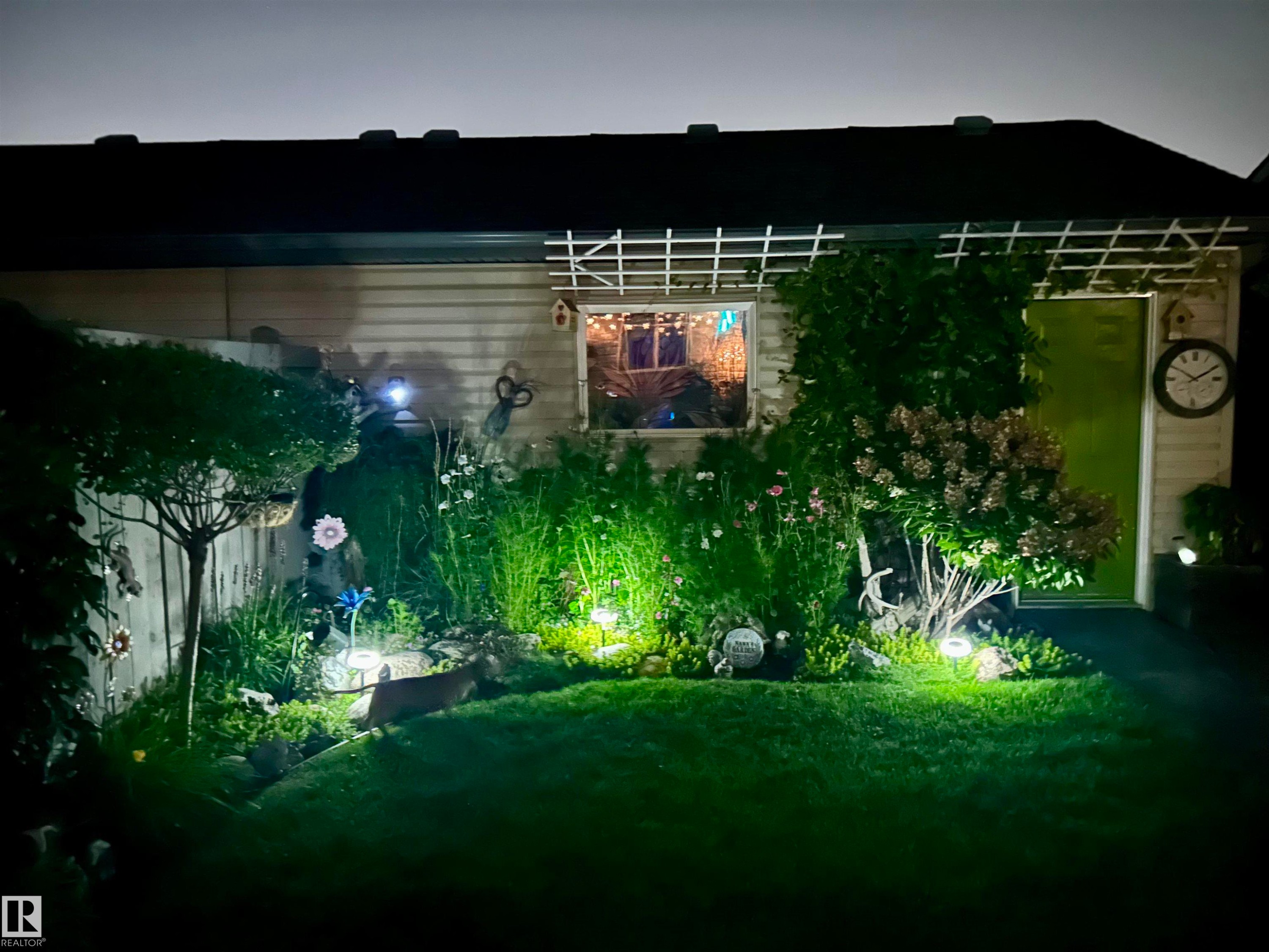 The property features a well-maintained lawn and garden area with various plants and decorative elements - 2914 18A Avenue, Edmonton, AB - Outdoor