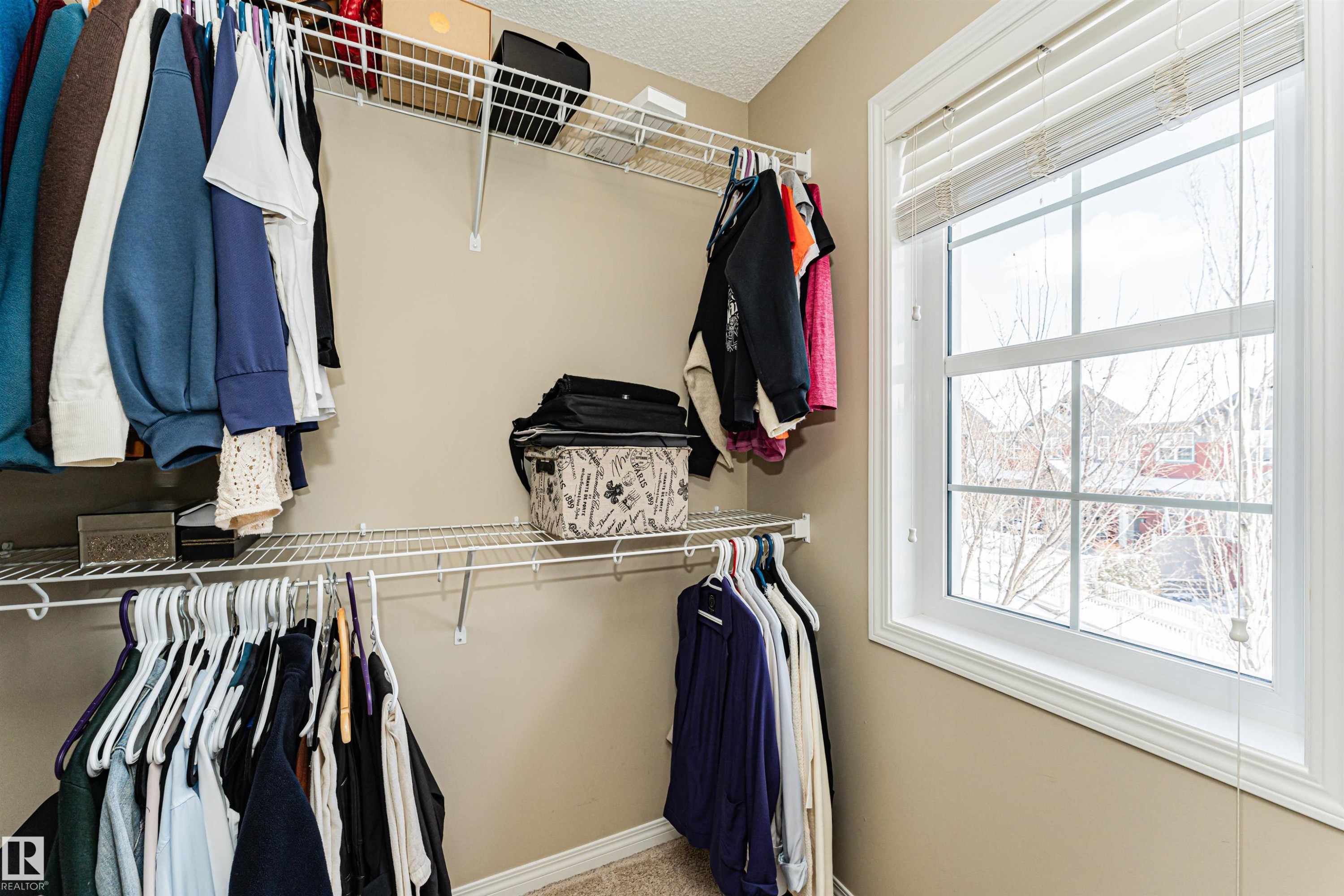This closet features wire shelving and hanging rods, providing ample storage solutions, along with a window that offers natural light - 31 4029 Orchards Drive, Edmonton, autreother - Indoor With Storage