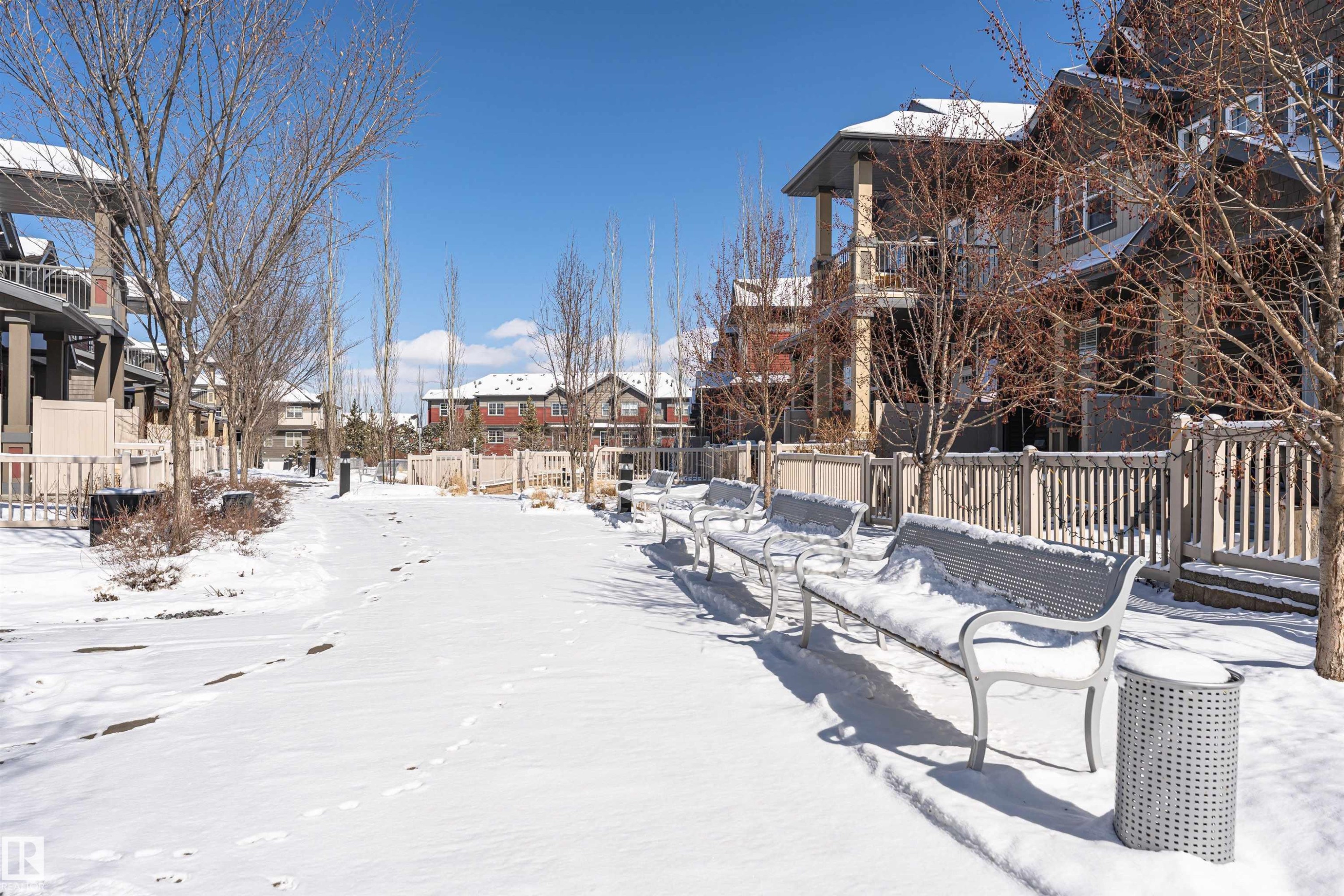 The property features a serene outdoor pathway lined with bare trees, benches, and fencing - 31 4029 Orchards Drive, Edmonton, autreother - Outdoor