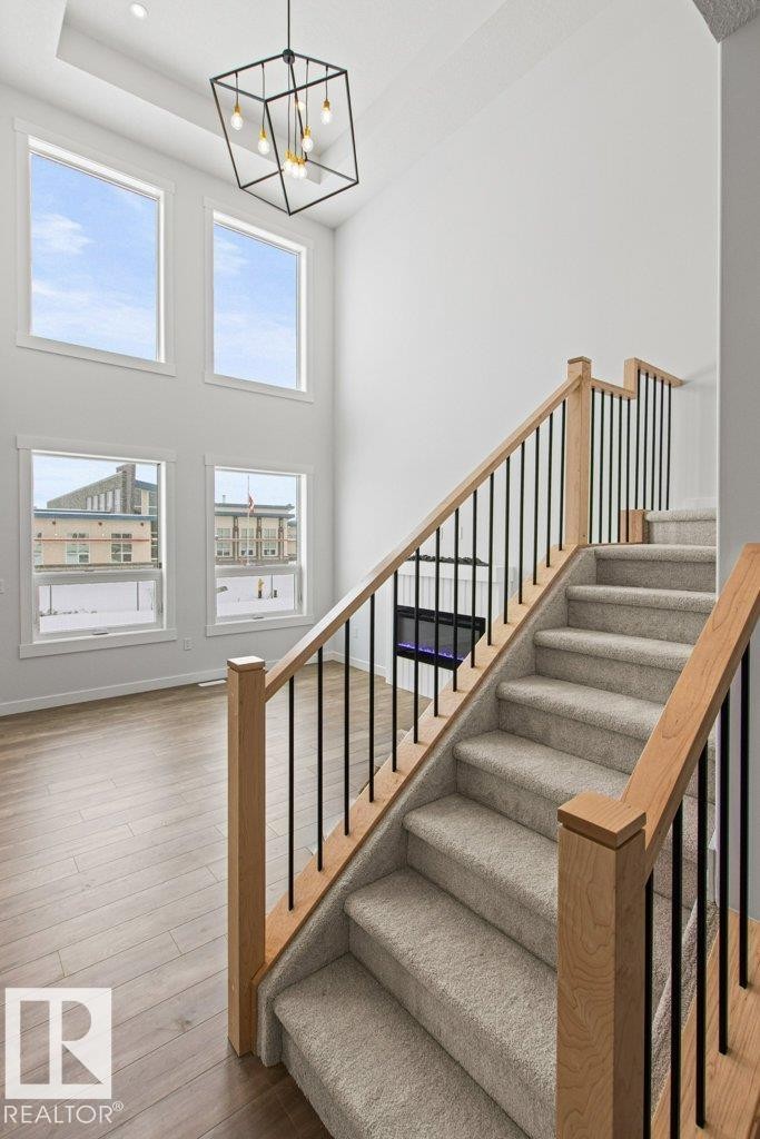 The property features a grand two-story living area with large windows providing ample natural light - 5018 53 Avenue, Calmar, AB - Indoor Photo Showing Other Room