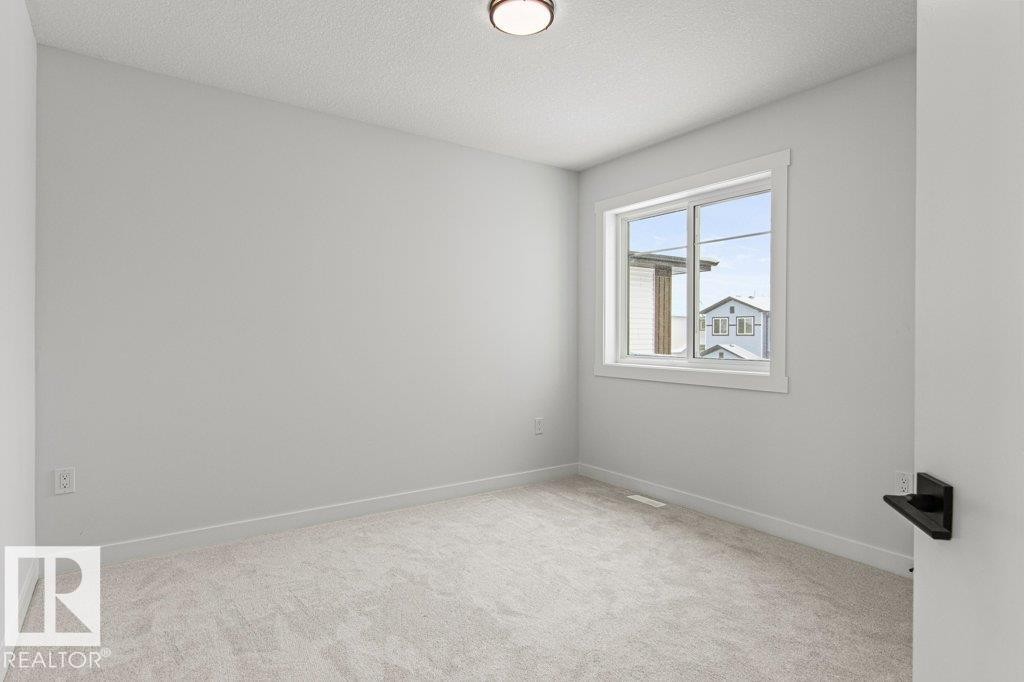 This room features light grey walls, a single window providing natural light, and light-colored carpet flooring - 5018 53 Avenue, Calmar, AB - Indoor Photo Showing Other Room