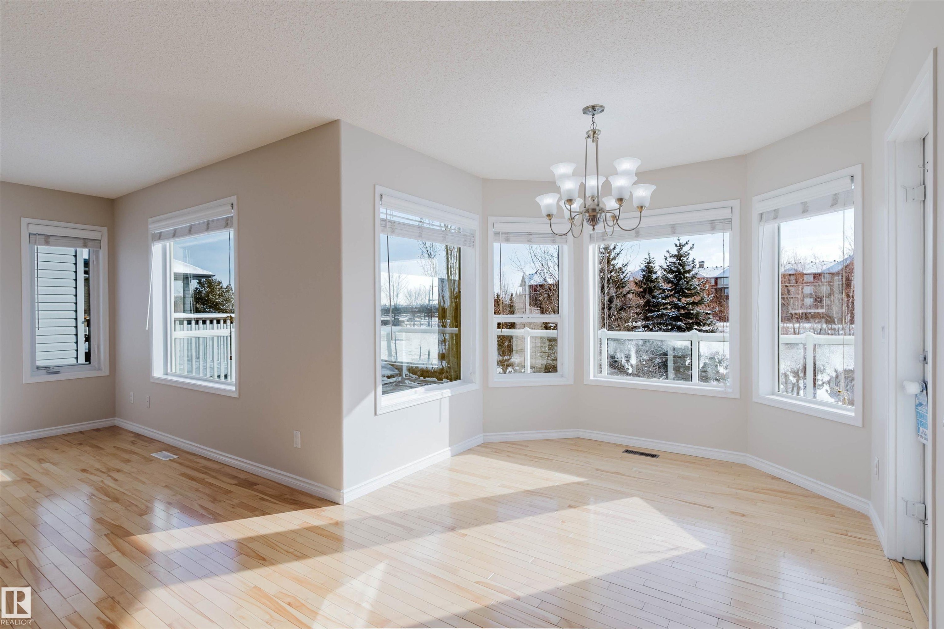 This bright living area features light hardwood flooring and numerous windows, providing ample natural light - 1135 112 Street, Edmonton, AB - Indoor Photo Showing Other Room