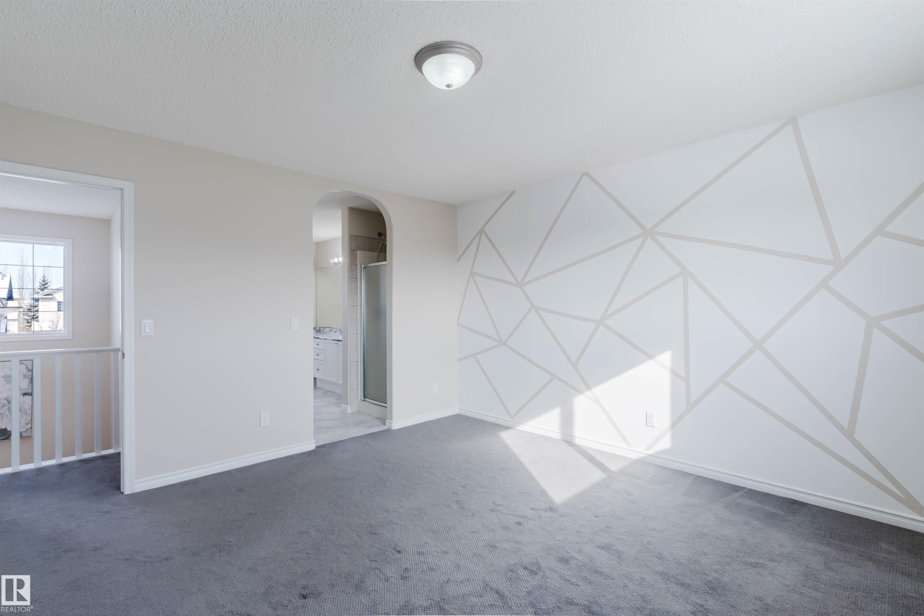 This room features plush gray carpeting and a decorative accent wall with a geometric pattern - 1135 112 Street, Edmonton, AB - Indoor Photo Showing Other Room