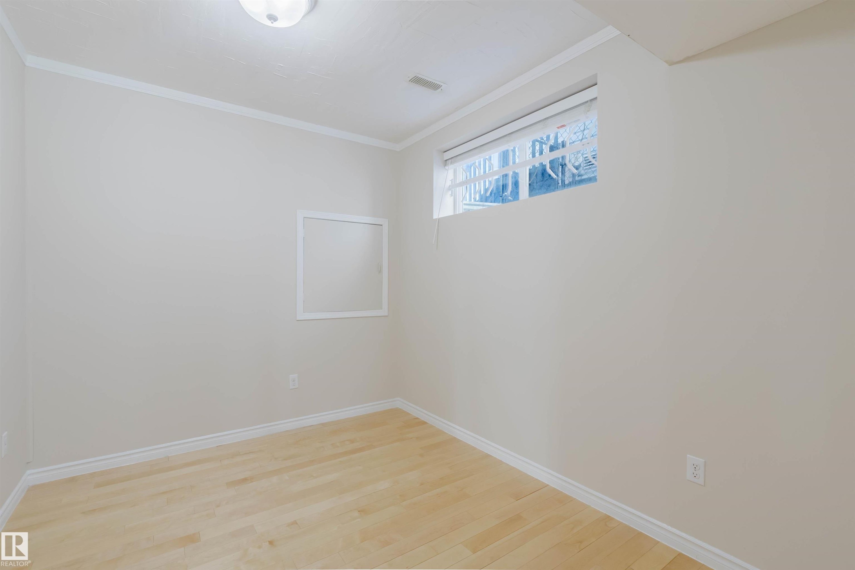 This room features light-colored walls, light-toned wood flooring, and a window providing natural light - 1135 112 Street, Edmonton, AB - Indoor Photo Showing Other Room