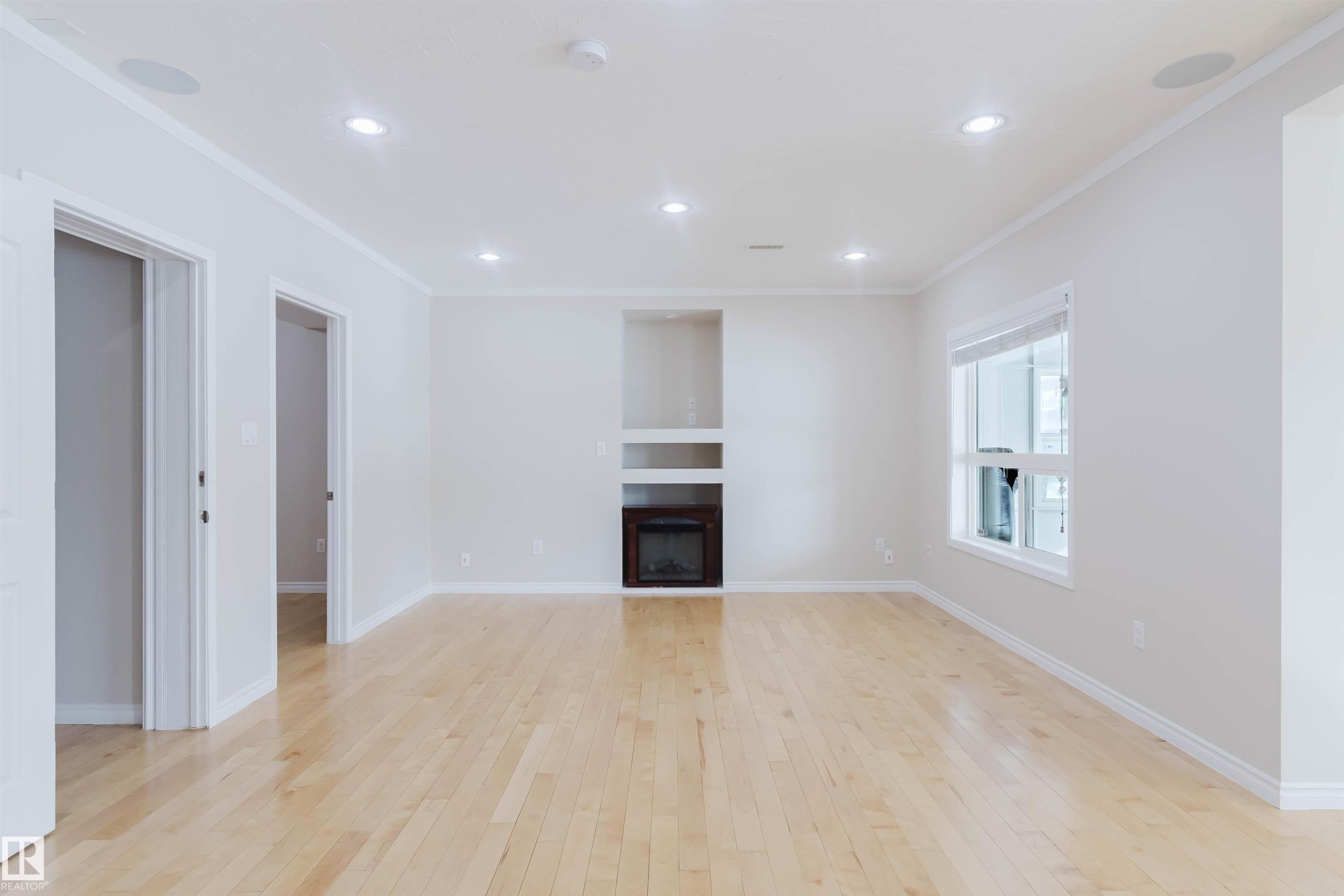 Bright room featuring hardwood floors, recessed lighting, and a built-in fireplace - 1135 112 Street, Edmonton, AB - Indoor With Fireplace