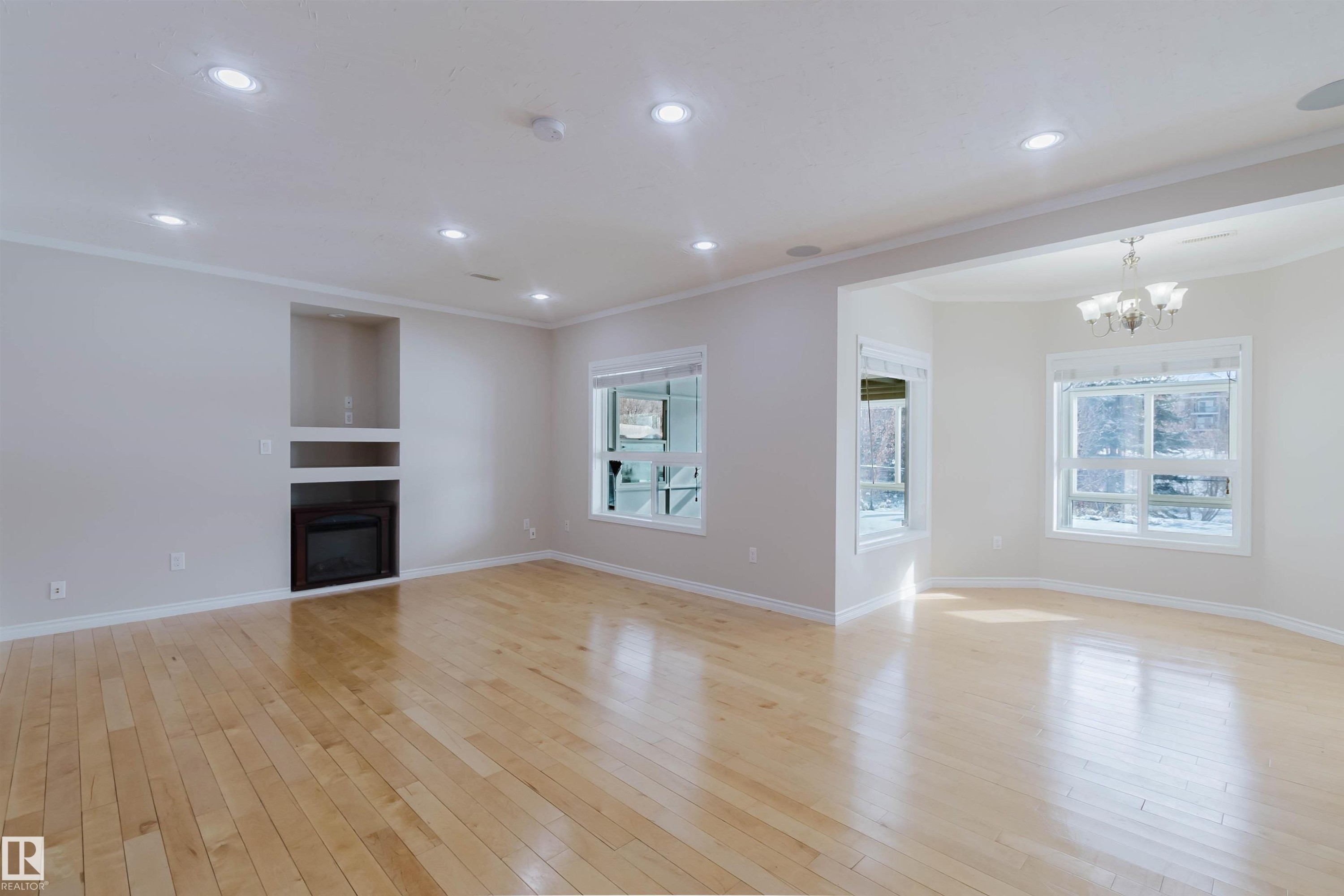 This spacious living area features light-colored hardwood flooring and recessed lighting throughout - 1135 112 Street, Edmonton, AB - Indoor