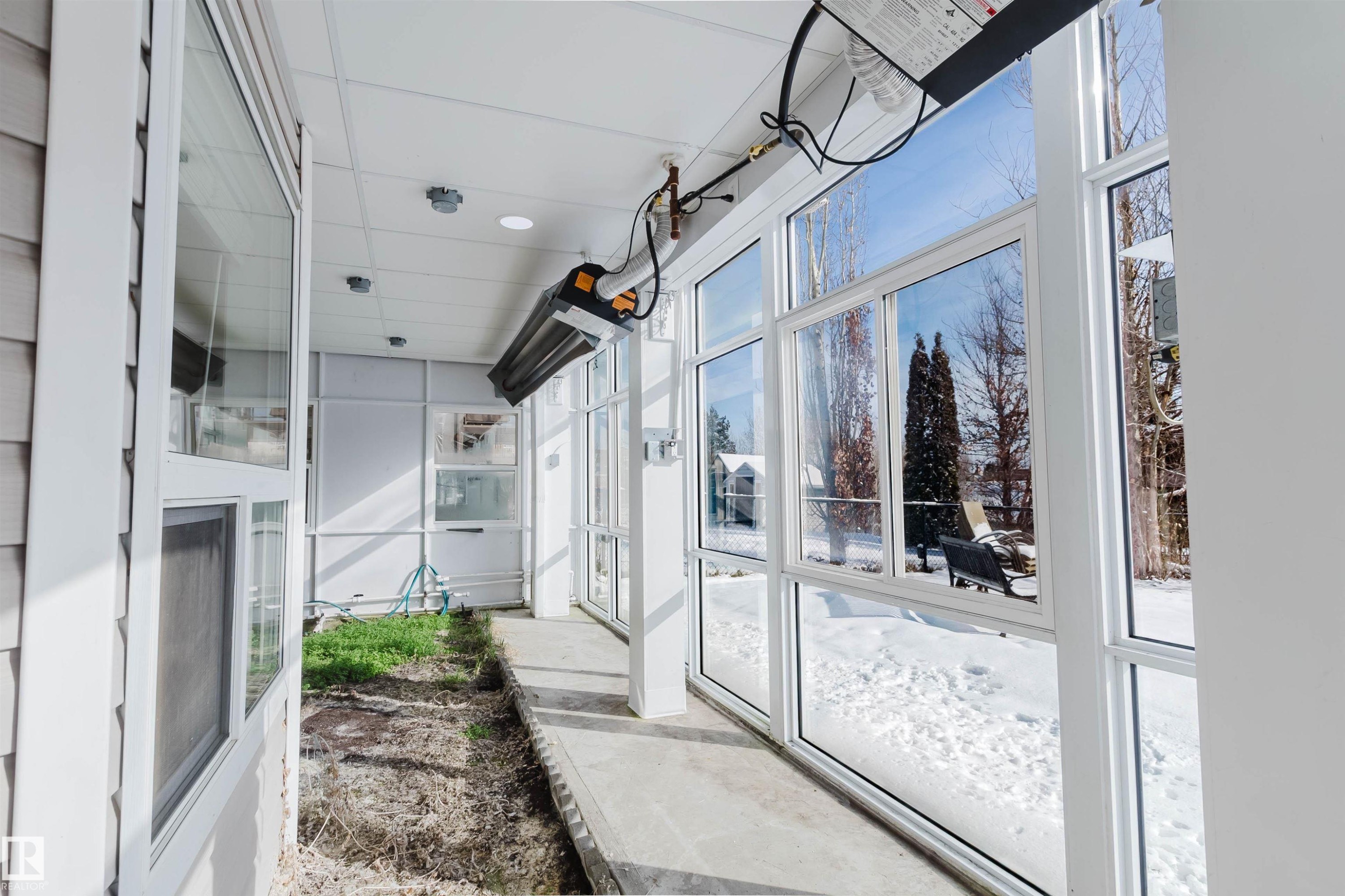 Enclosed patio area with large windows, providing views of the exterior - 1135 112 Street, Edmonton, AB - Photo Showing Other Room