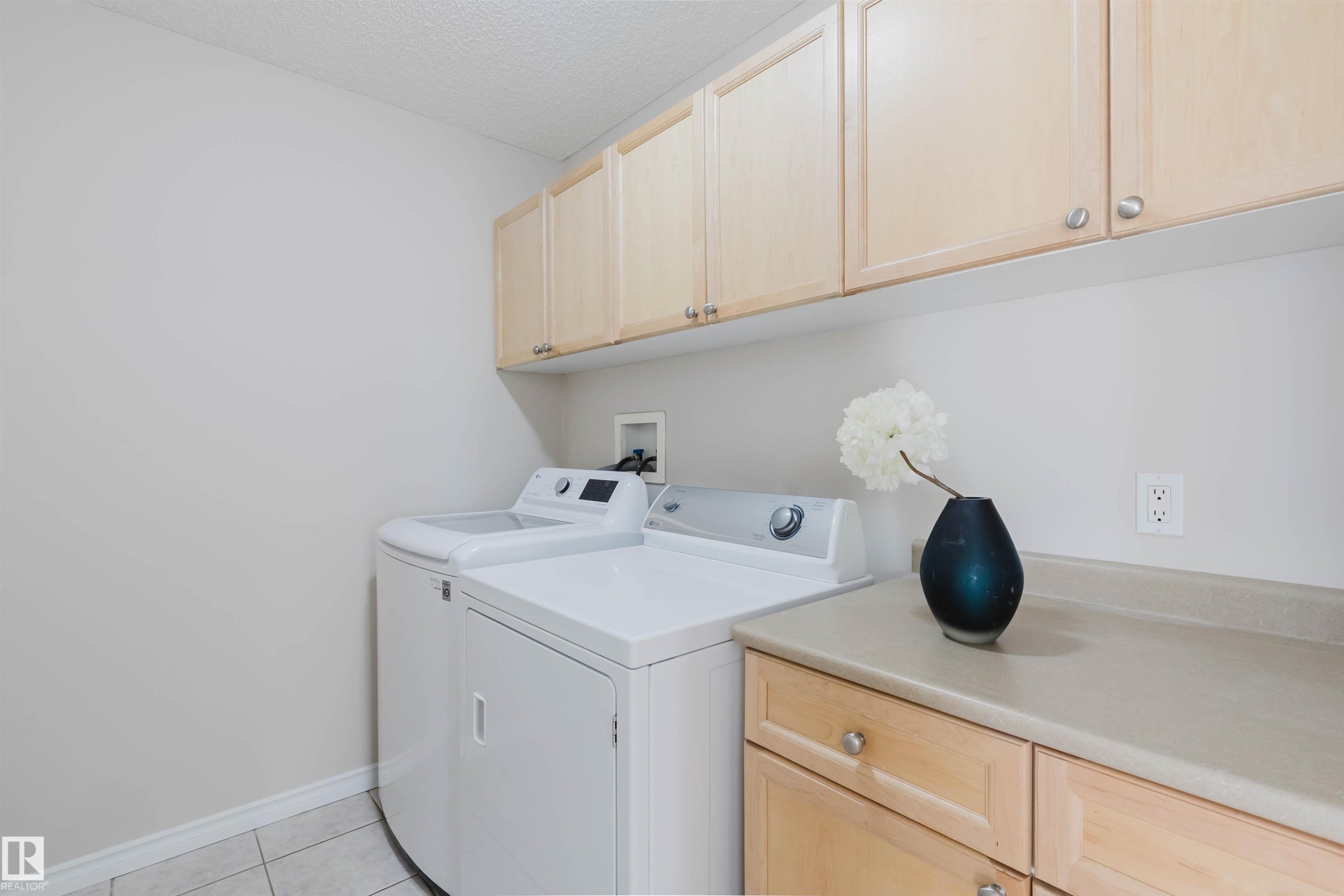Utility area featuring overhead and base cabinetry, a countertop, and tile flooring - 1135 112 Street, Edmonton, AB - Indoor Photo Showing Laundry Room