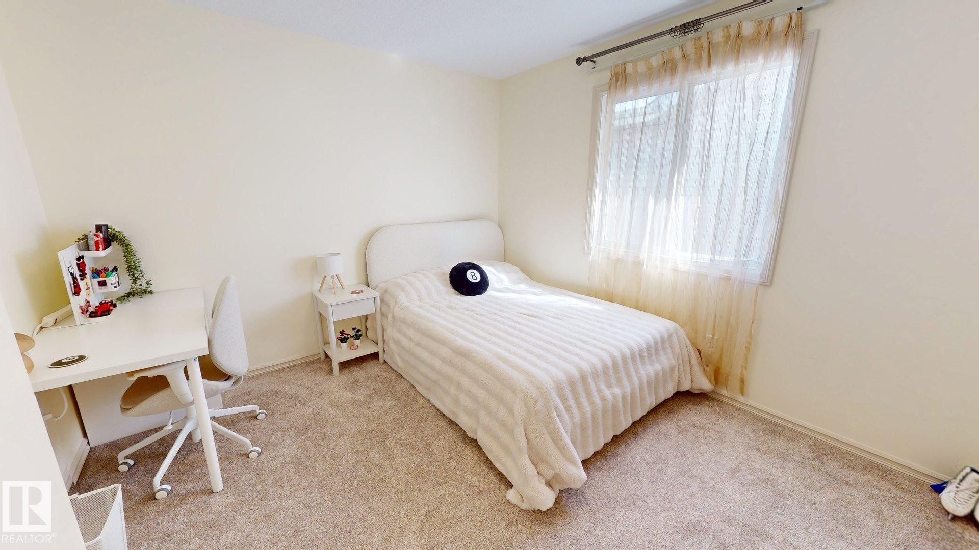 Carpeted room featuring light-colored walls and a window with sheer curtains - 1609 Hodgson Crest, Edmonton, AB - Indoor Photo Showing Bedroom