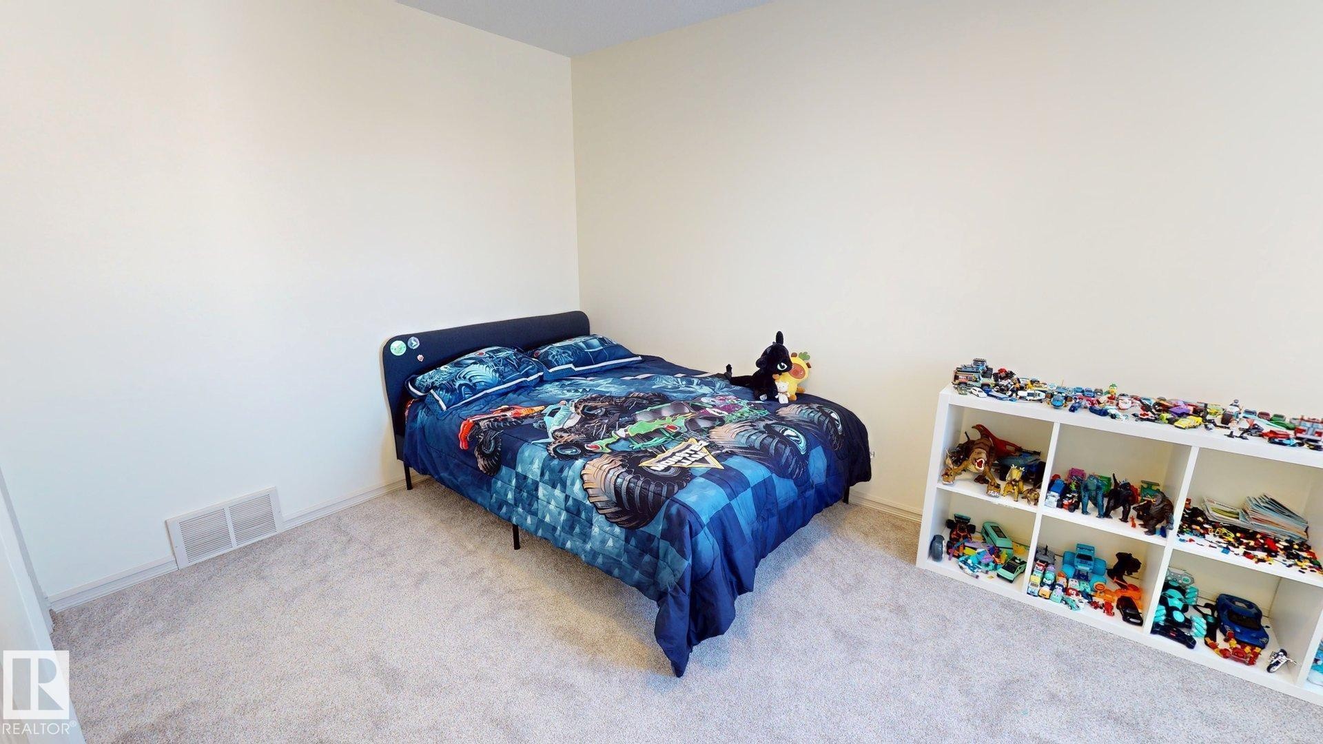 This room features neutral colored walls and light-toned carpet flooring - 1609 Hodgson Crest, Edmonton, AB - Indoor Photo Showing Bedroom