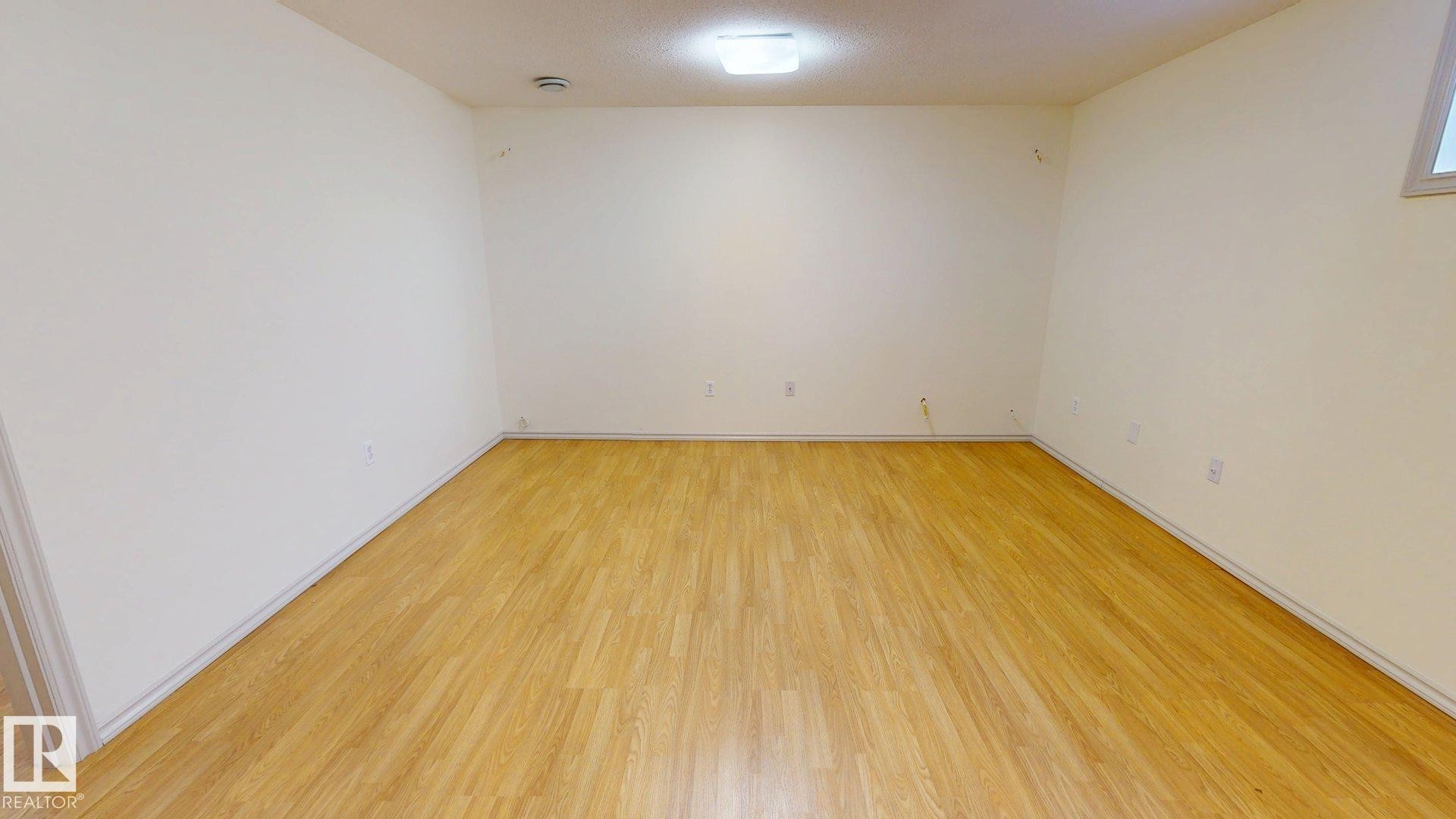 This room features light-colored walls and light wood-style flooring, complemented by a ceiling-mounted light fixture - 1609 Hodgson Crest, Edmonton, AB - Indoor Photo Showing Other Room