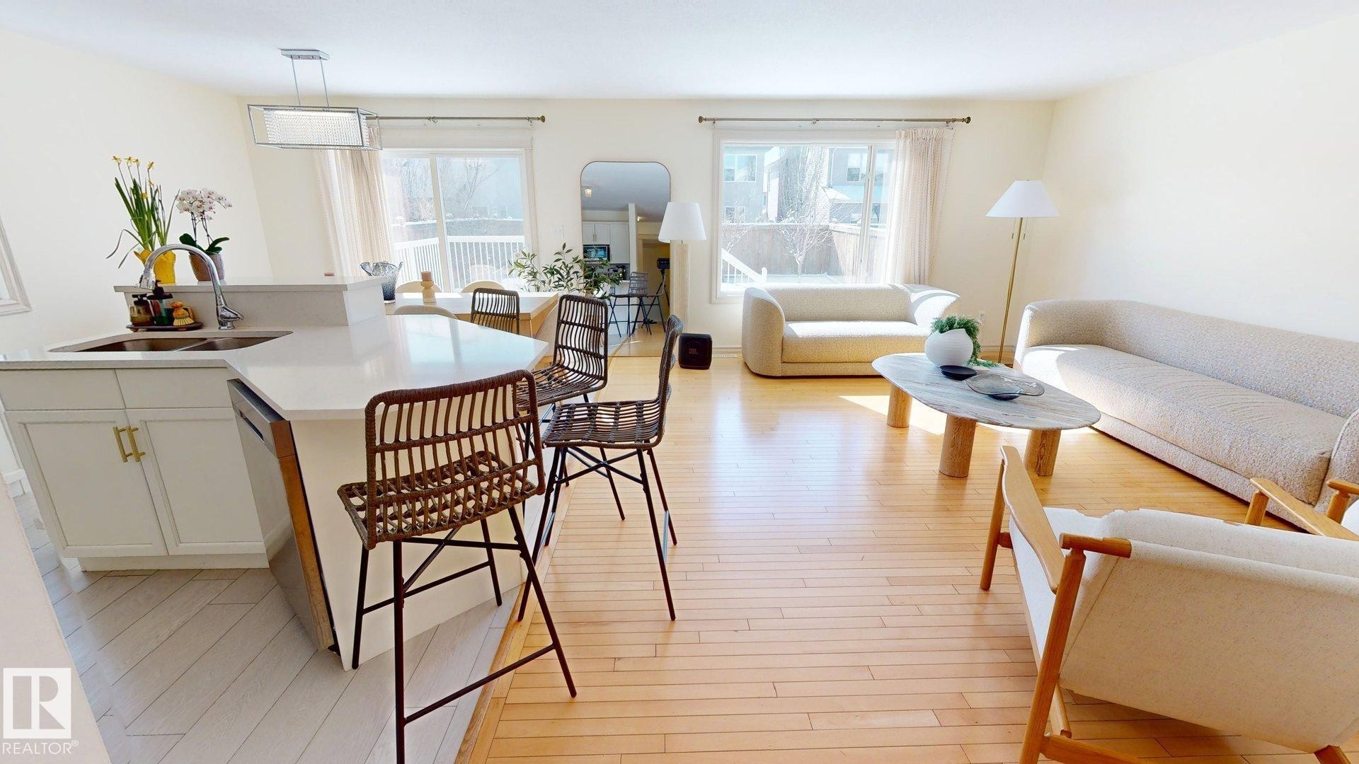 The open concept living area features hardwood floors, white walls, and bright windows, providing an inviting atmosphere - 1609 Hodgson Crest, Edmonton, AB - Indoor