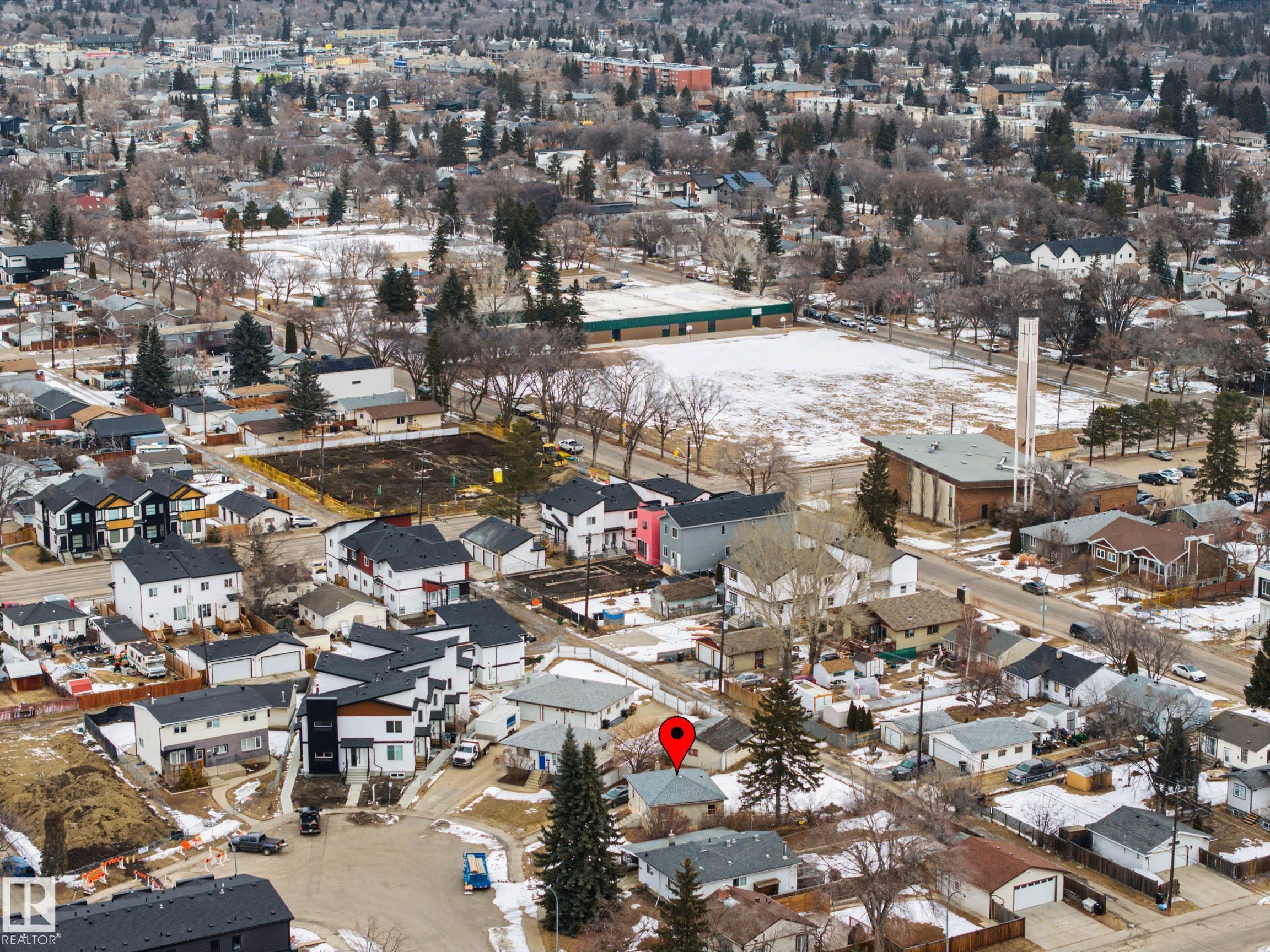 Aerial view of the property and surrounding neighborhood, featuring residential homes, a large open field, and mature trees - 9409 154 Street, Edmonton, AB - Outdoor With View