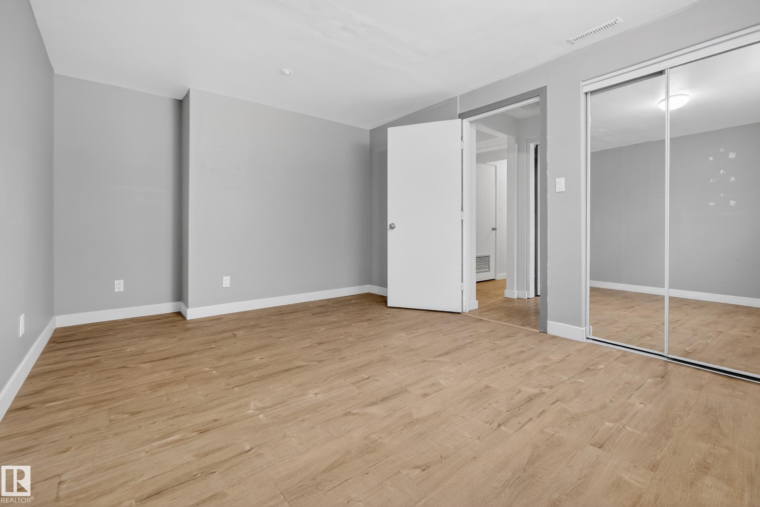 This room features durable plank flooring and light gray walls, offering a versatile aesthetic - 3613 113 Avenue, Edmonton, AB - Indoor Photo Showing Other Room