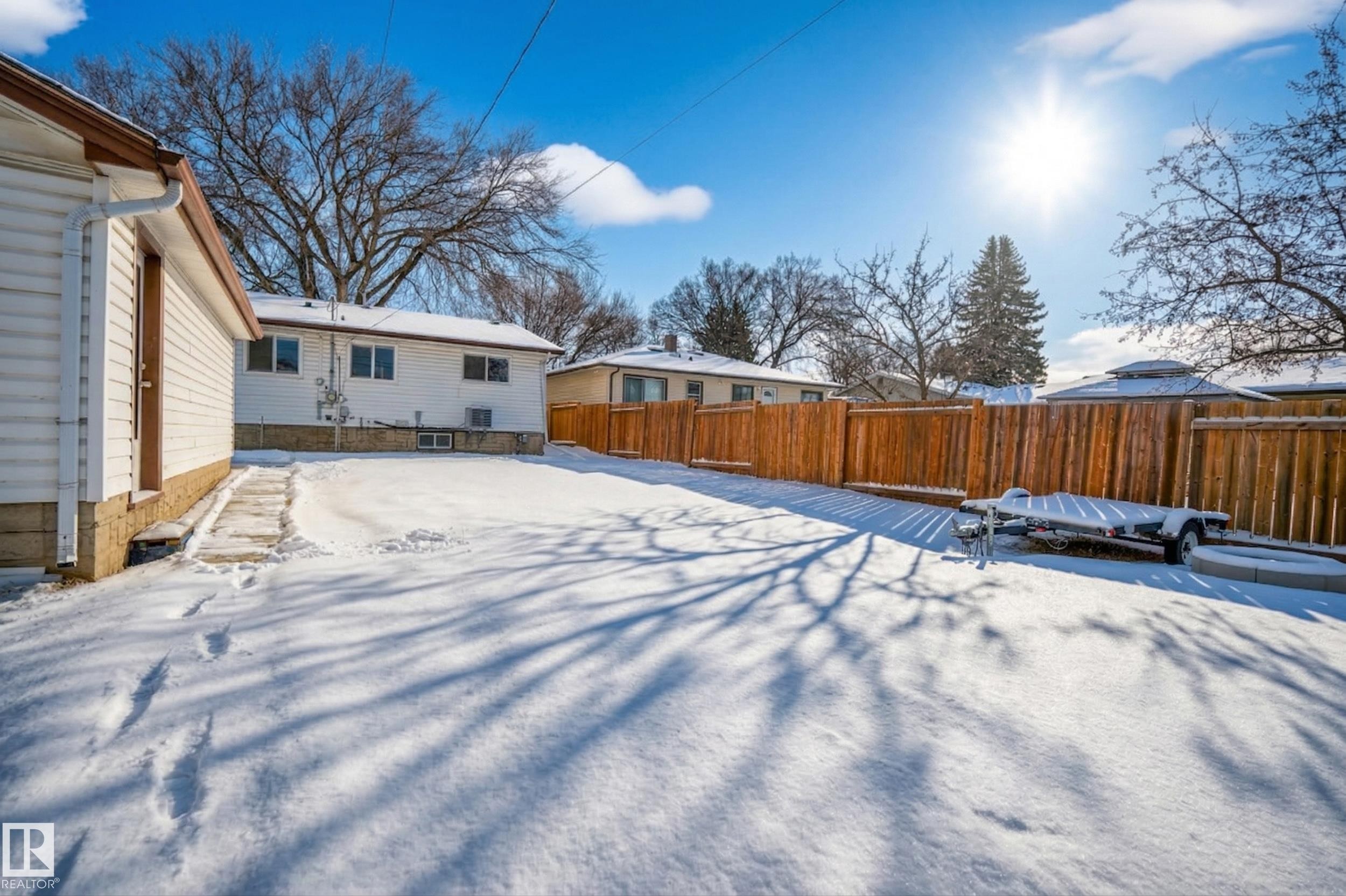 The property features a spacious yard with a clear pathway leading to the rear entrance of the residence - 3613 113 Avenue, Edmonton, AB - Outdoor